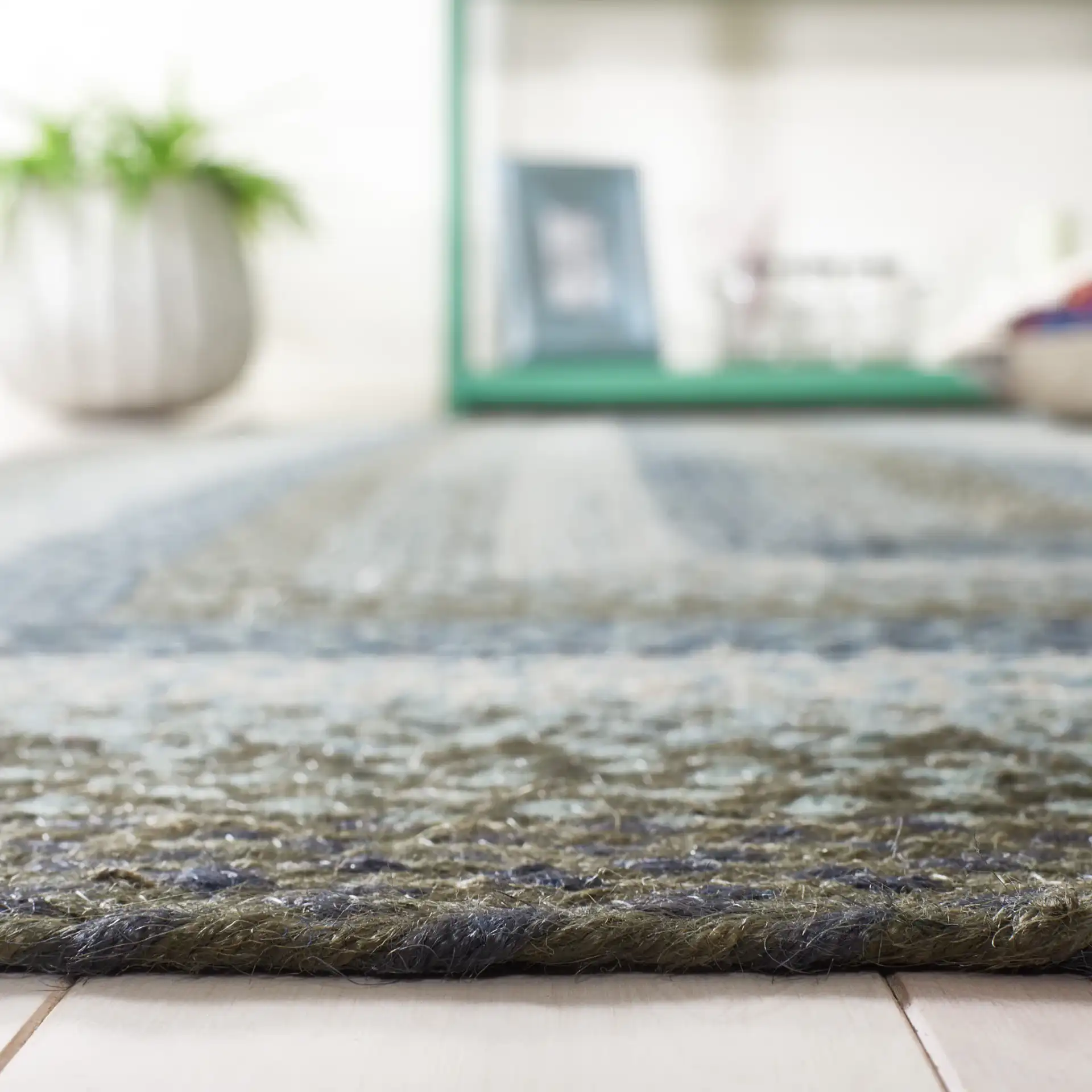 Braided Coastal Geometric Jute Rug in Light Blue / Green in a styled room