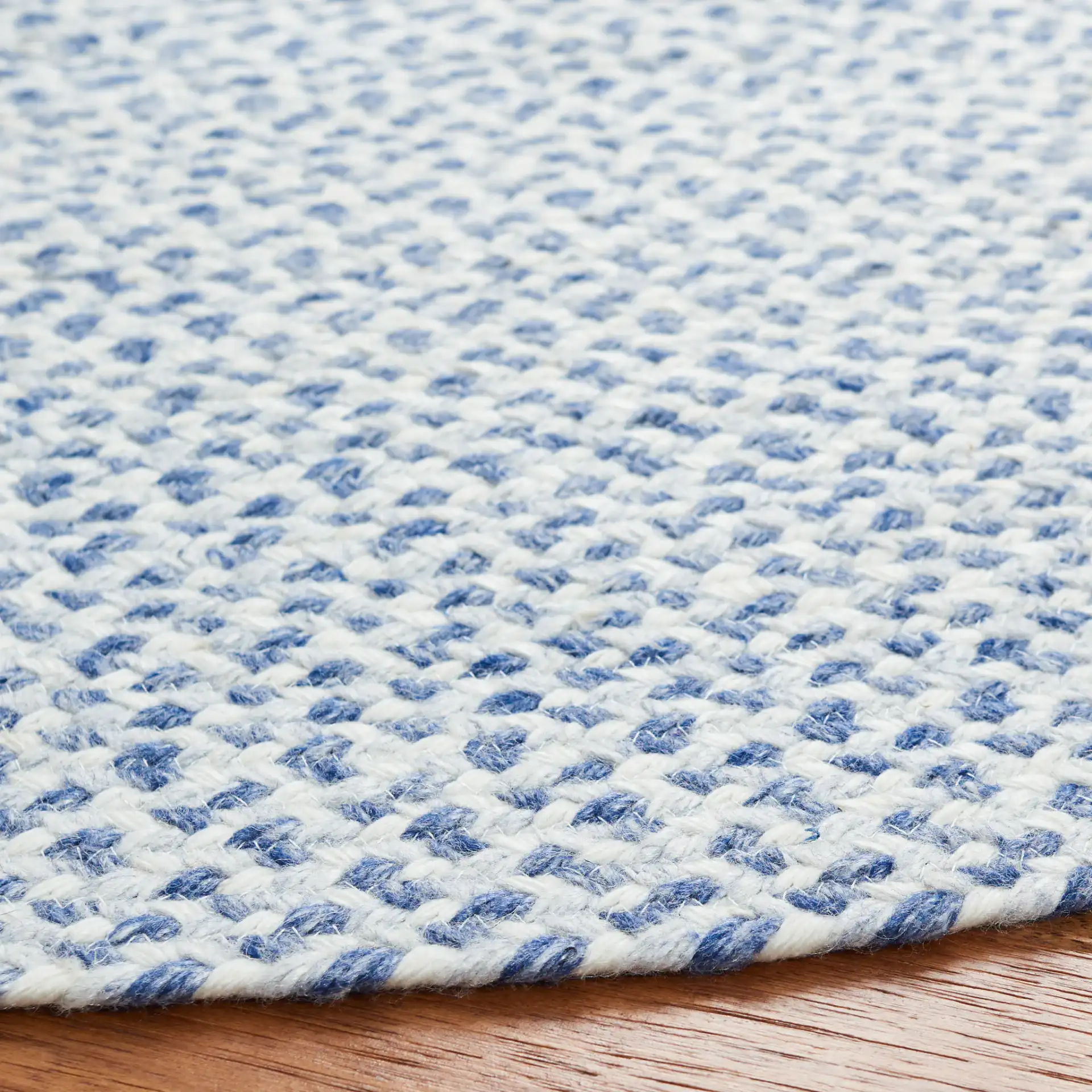 Braided Coastal Flecked Spiral Hand-Woven Rug in Blue / Ivory in a styled room
