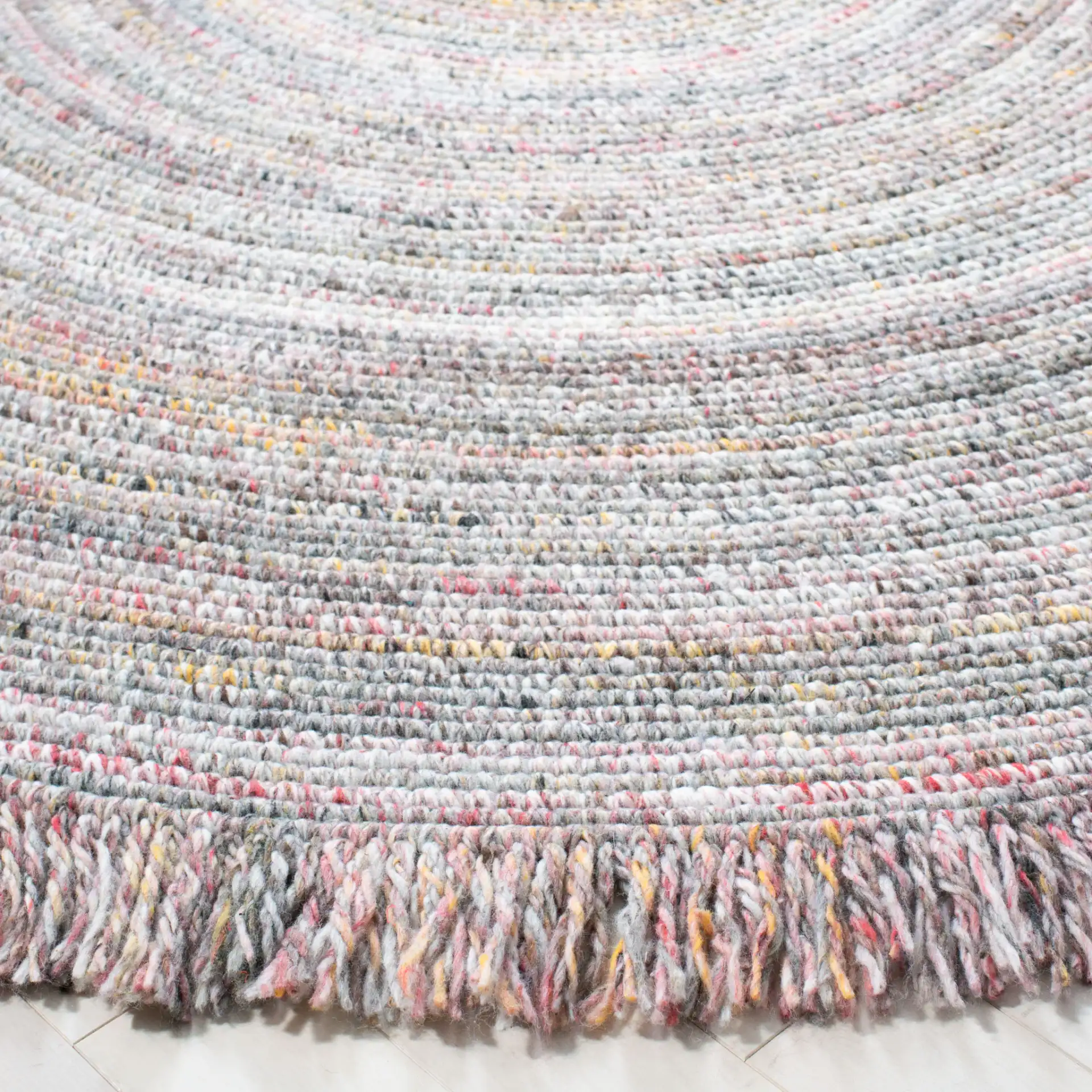 Braided Coastal Fringed Hand-Woven Rug in Gray / Red in a styled room