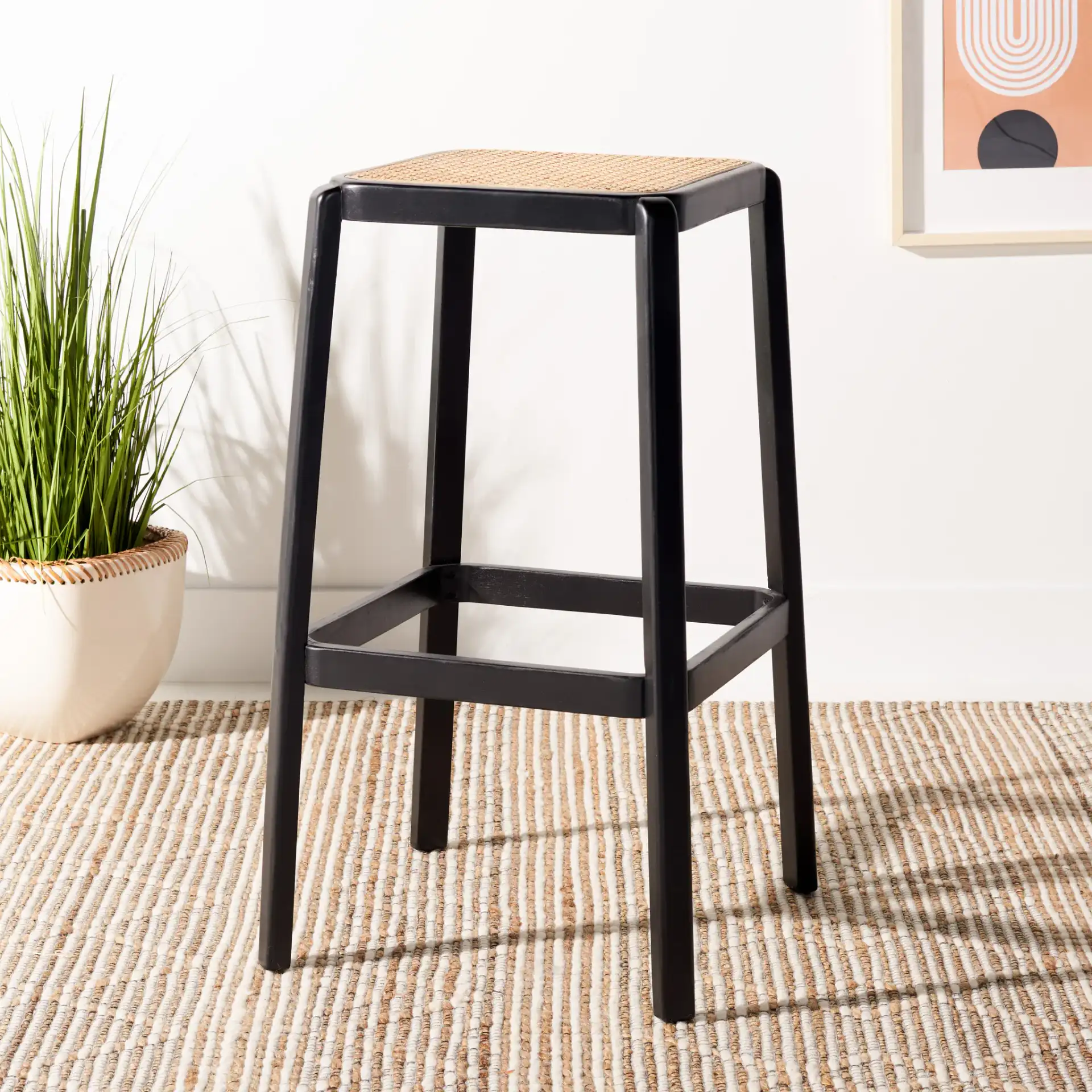 Silus Backless Cane Bar Stool in Black / Natural in a styled room