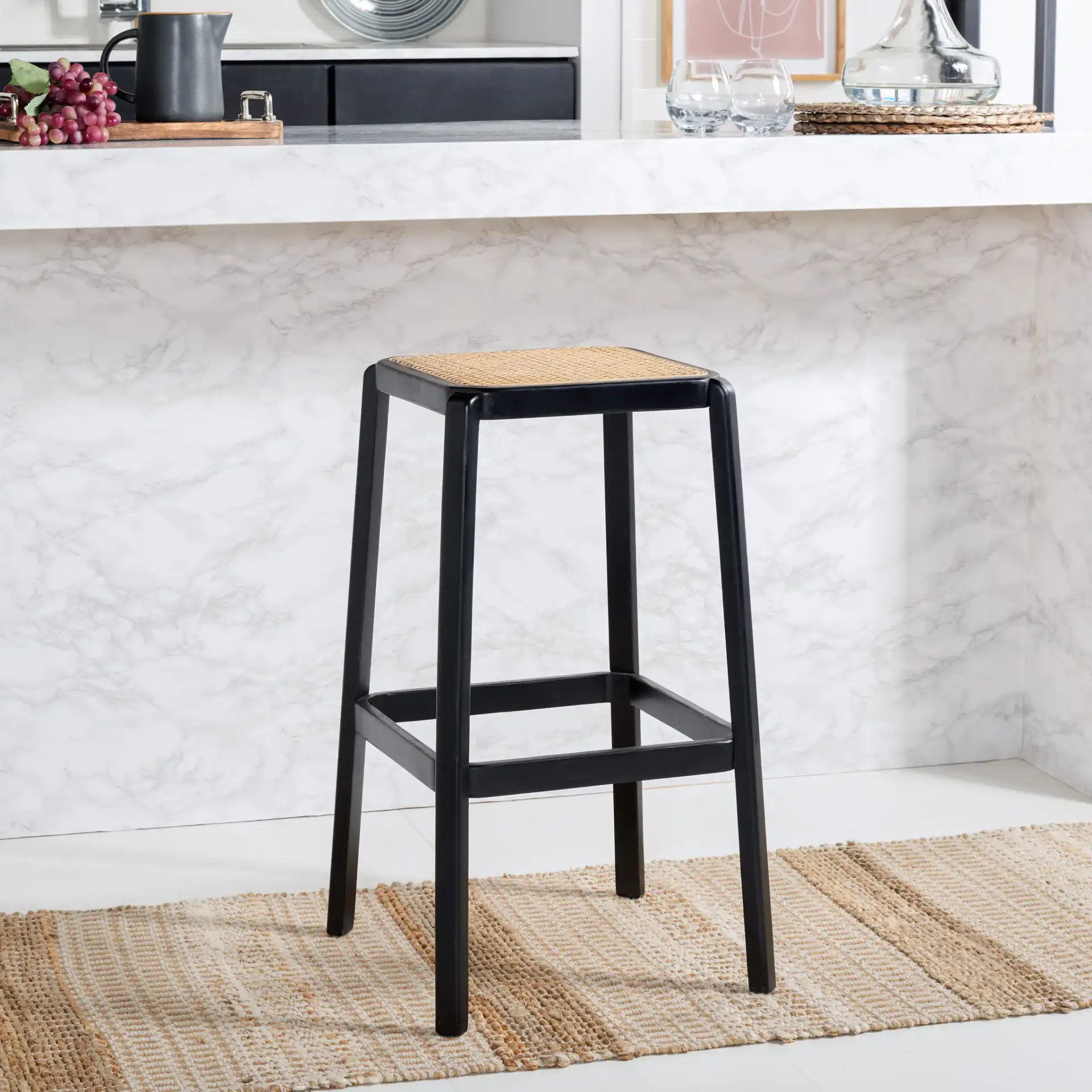 Silus Backless Cane Bar Stool in Black / Natural in a styled room