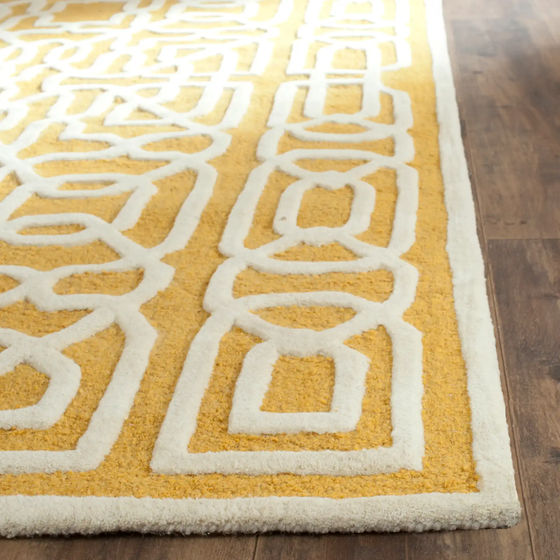 Cambridge Interlocking Fretwork Hand-Tufted Wool Rug in Gold / Ivory in a styled room