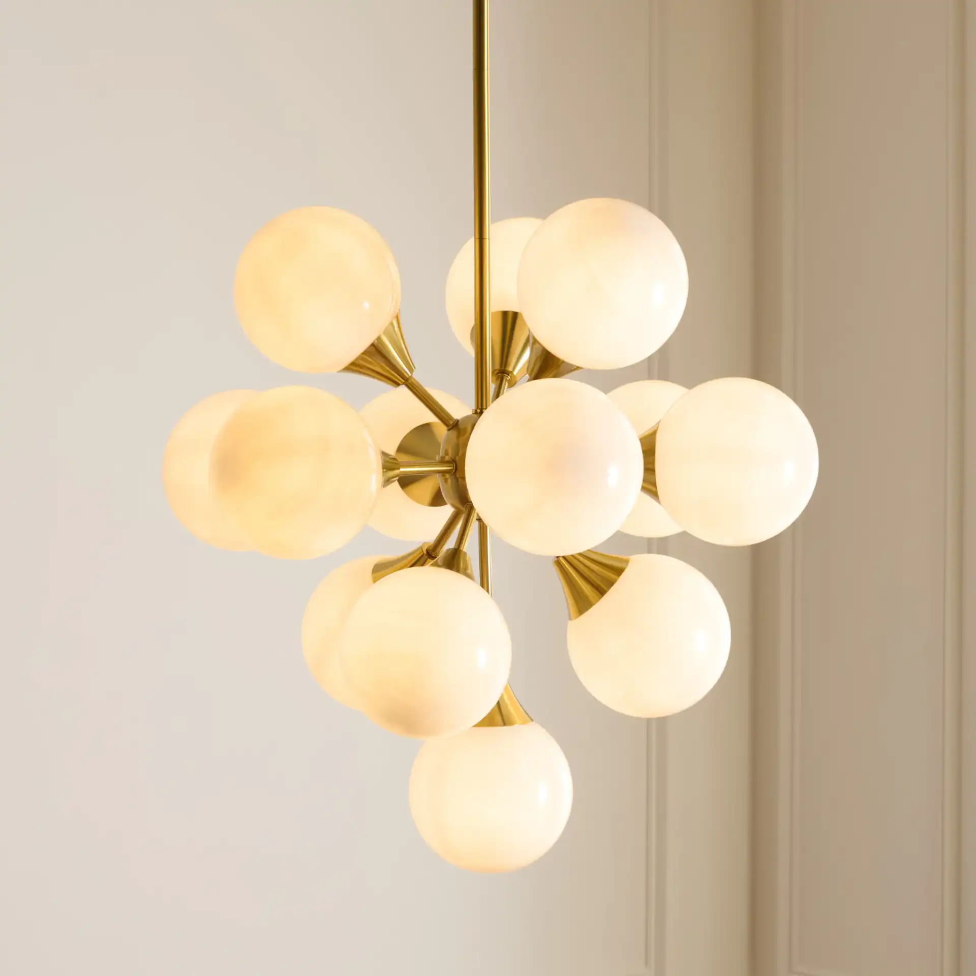Delvine Thirteen-Light Chandelier in Brass / White in a styled room
