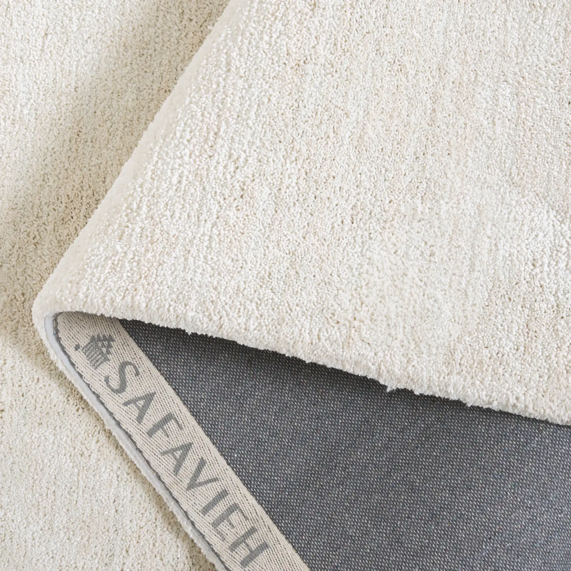 Carmine Ribbed Solid Hand-Tufted Rug in Ivory in a styled room