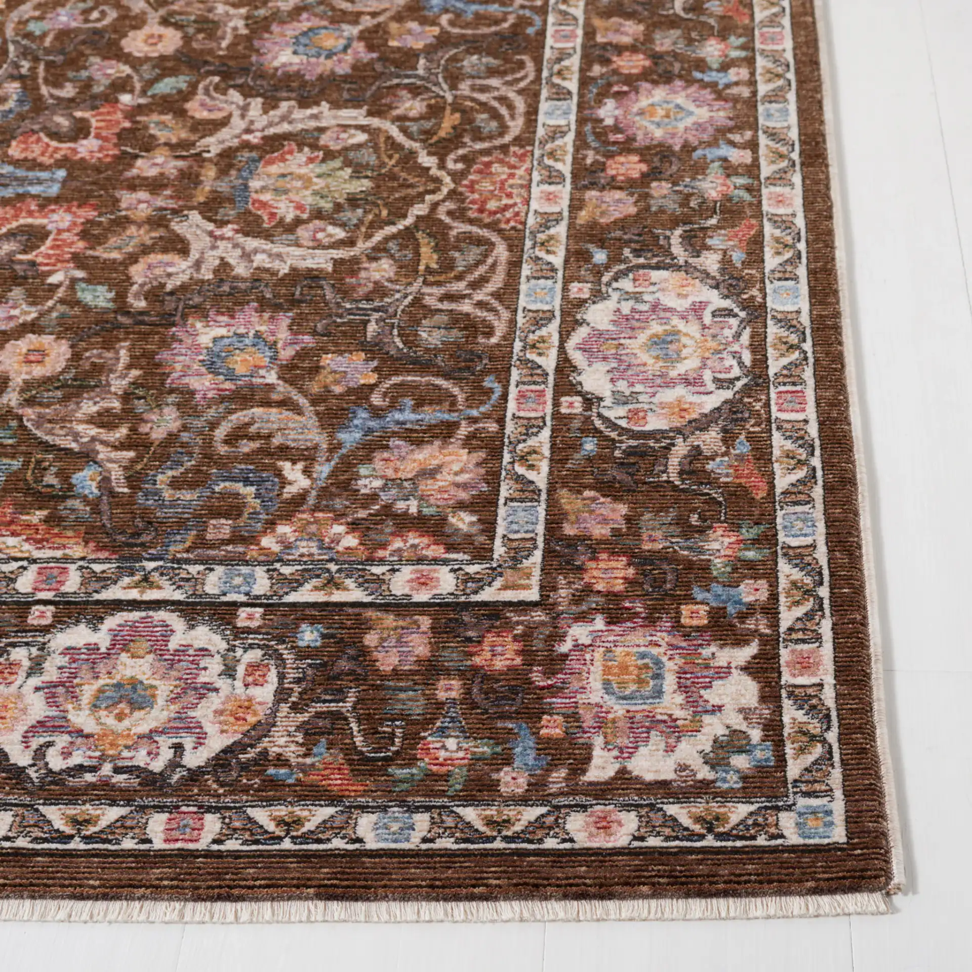 Crimson Floral Border Rug in Brown / Blue in a styled room