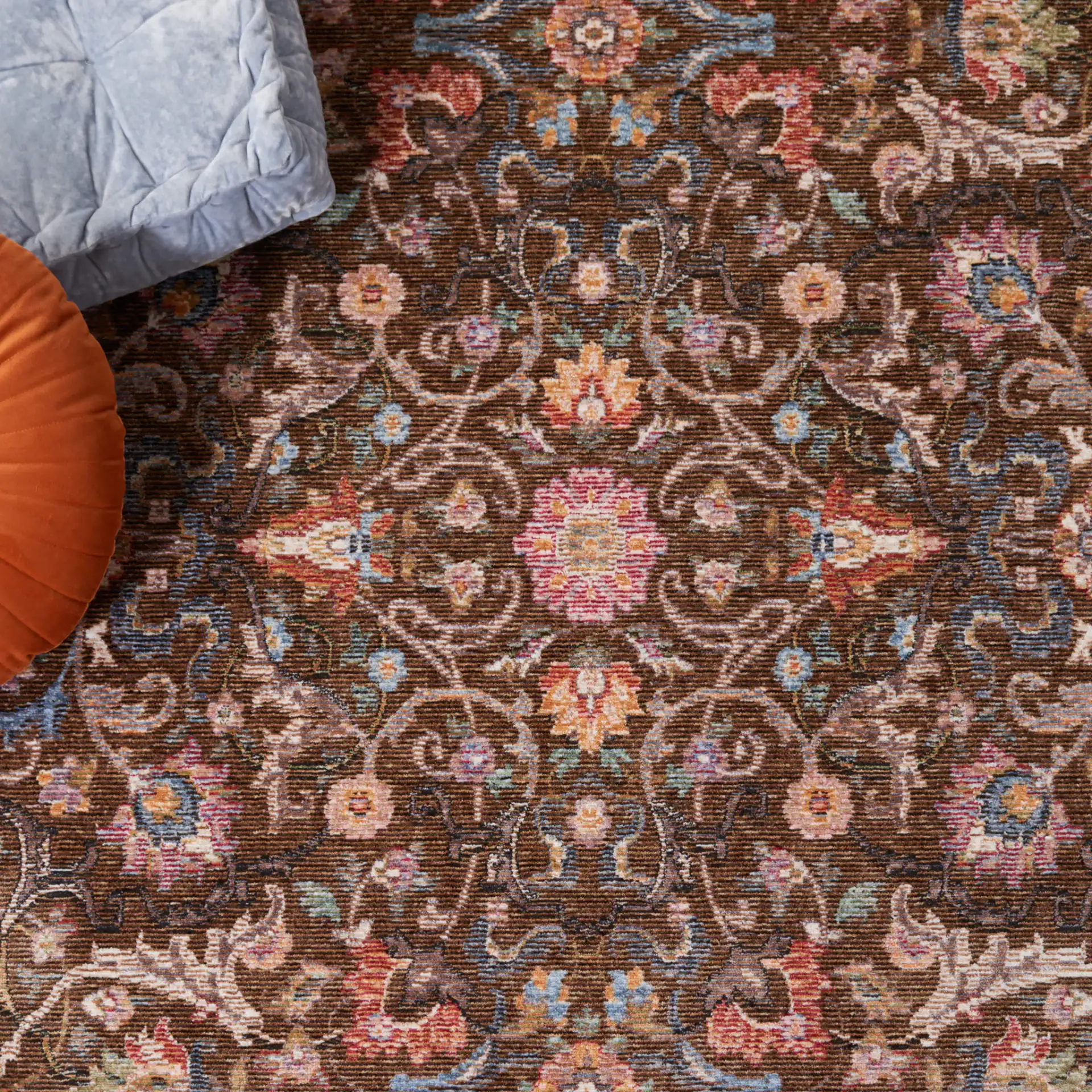 Crimson Floral Border Rug in Brown / Blue in a styled room