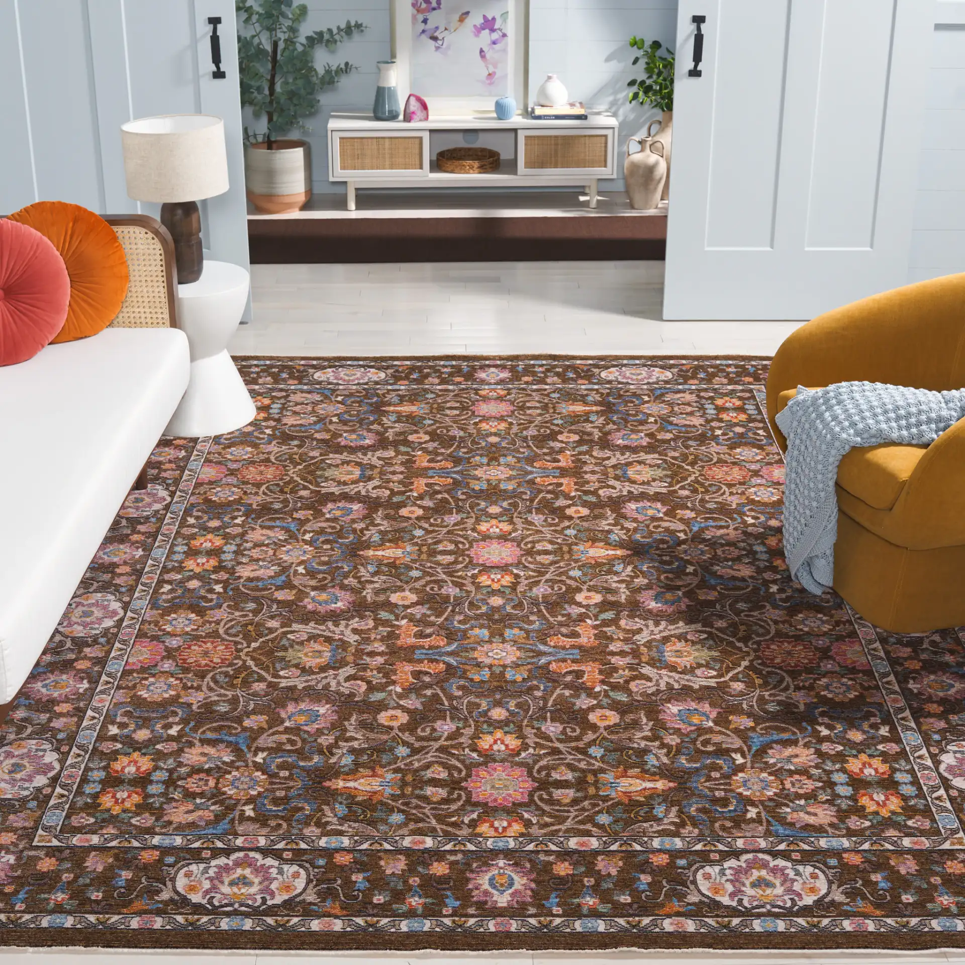 Crimson Floral Border Rug in Brown / Blue in a styled room