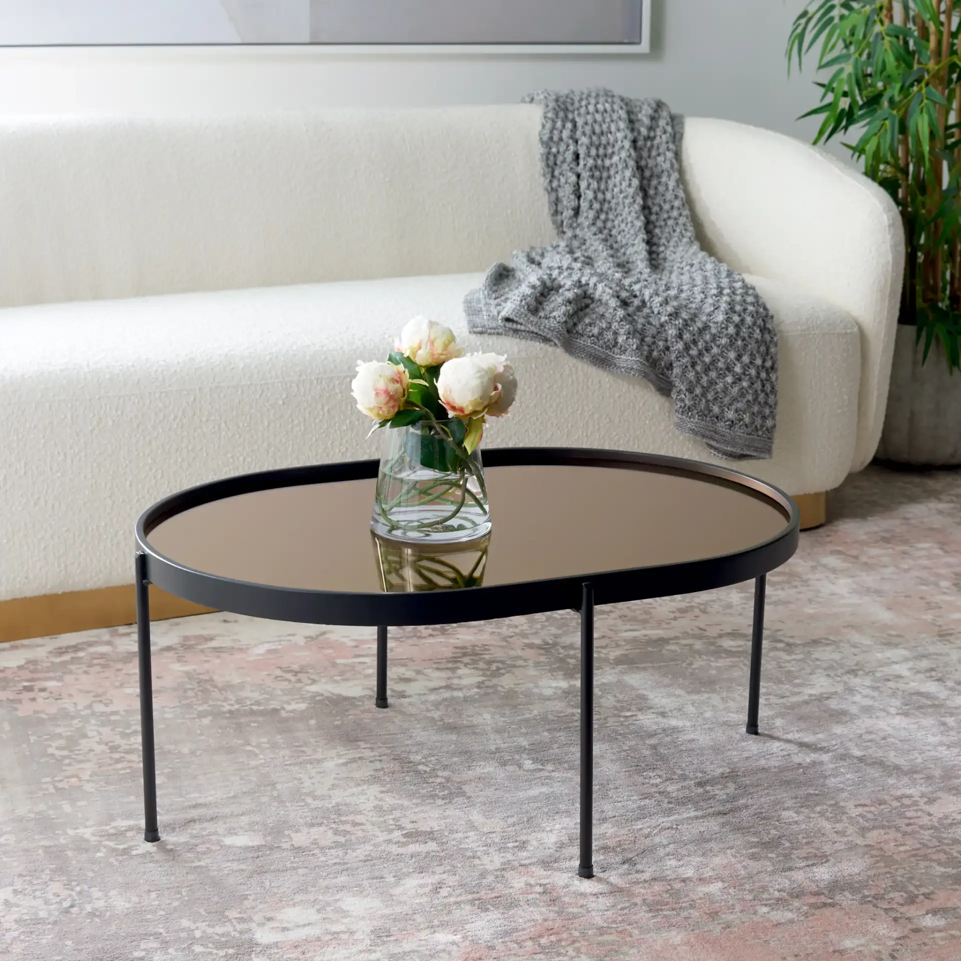 Emmerich Mirrored Coffee Table in Rose Gold / Matte Black in a styled room
