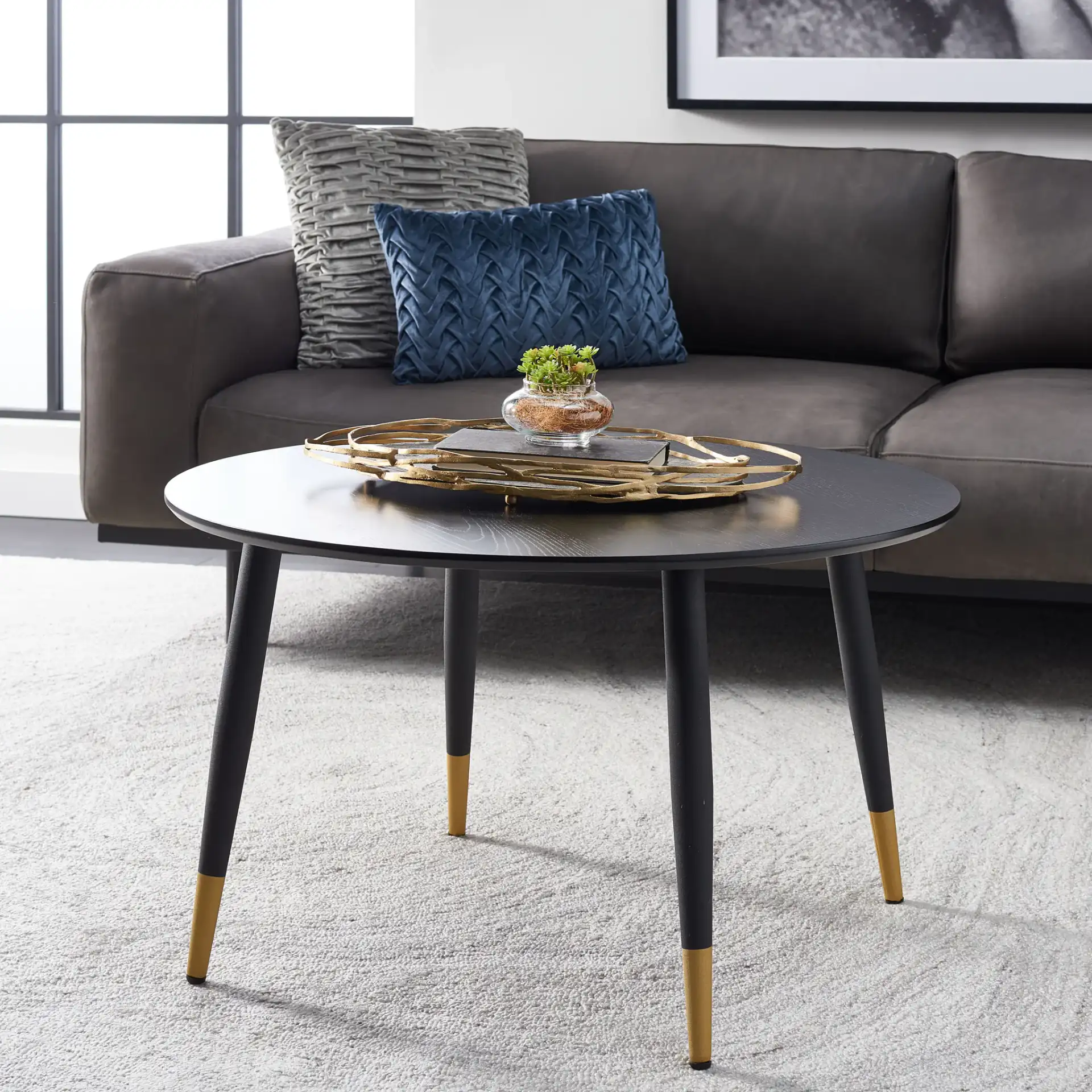 Beck Round Coffee Table in Black / Gold in a styled room