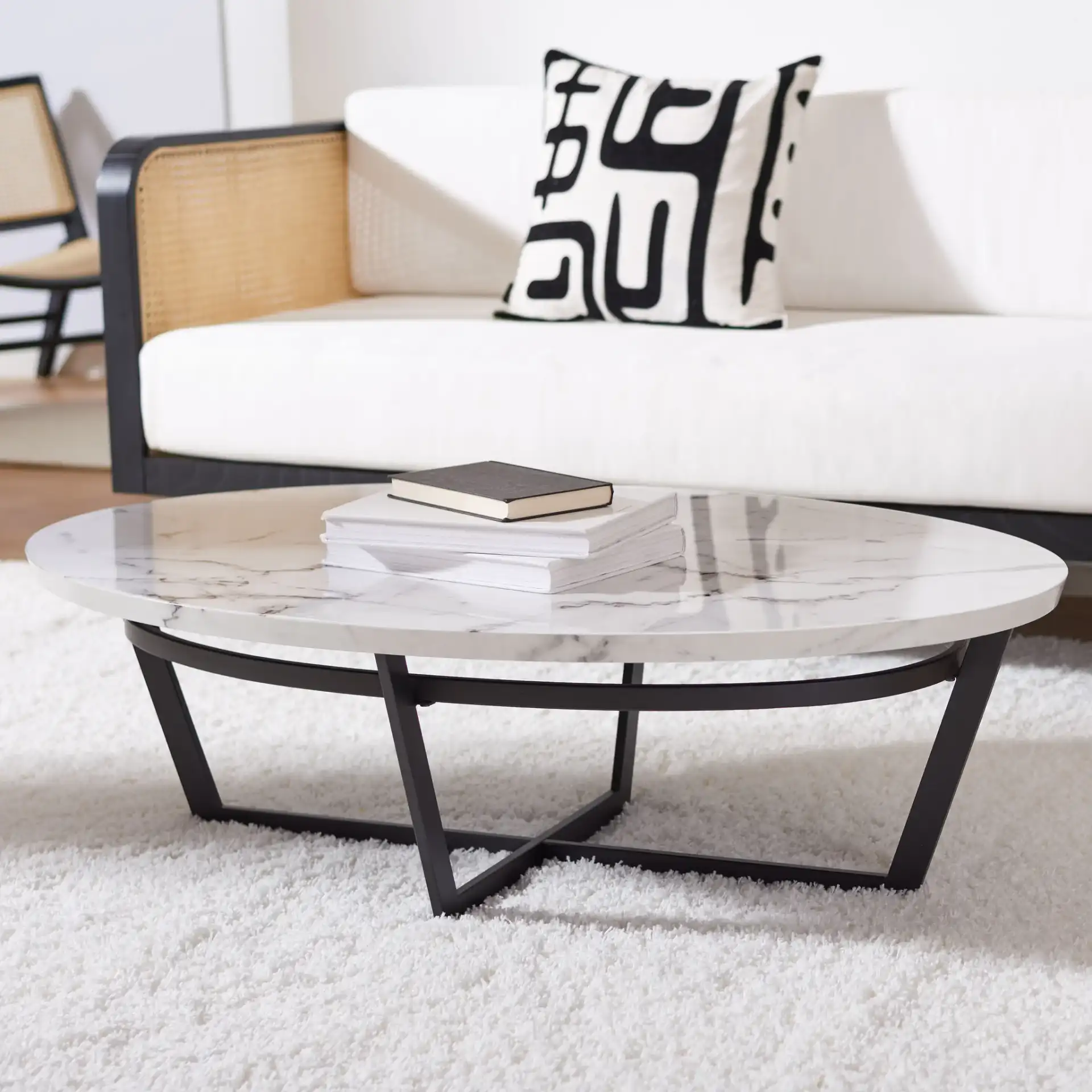 Placido Oval Coffee Table in White Marble / Black in a styled room