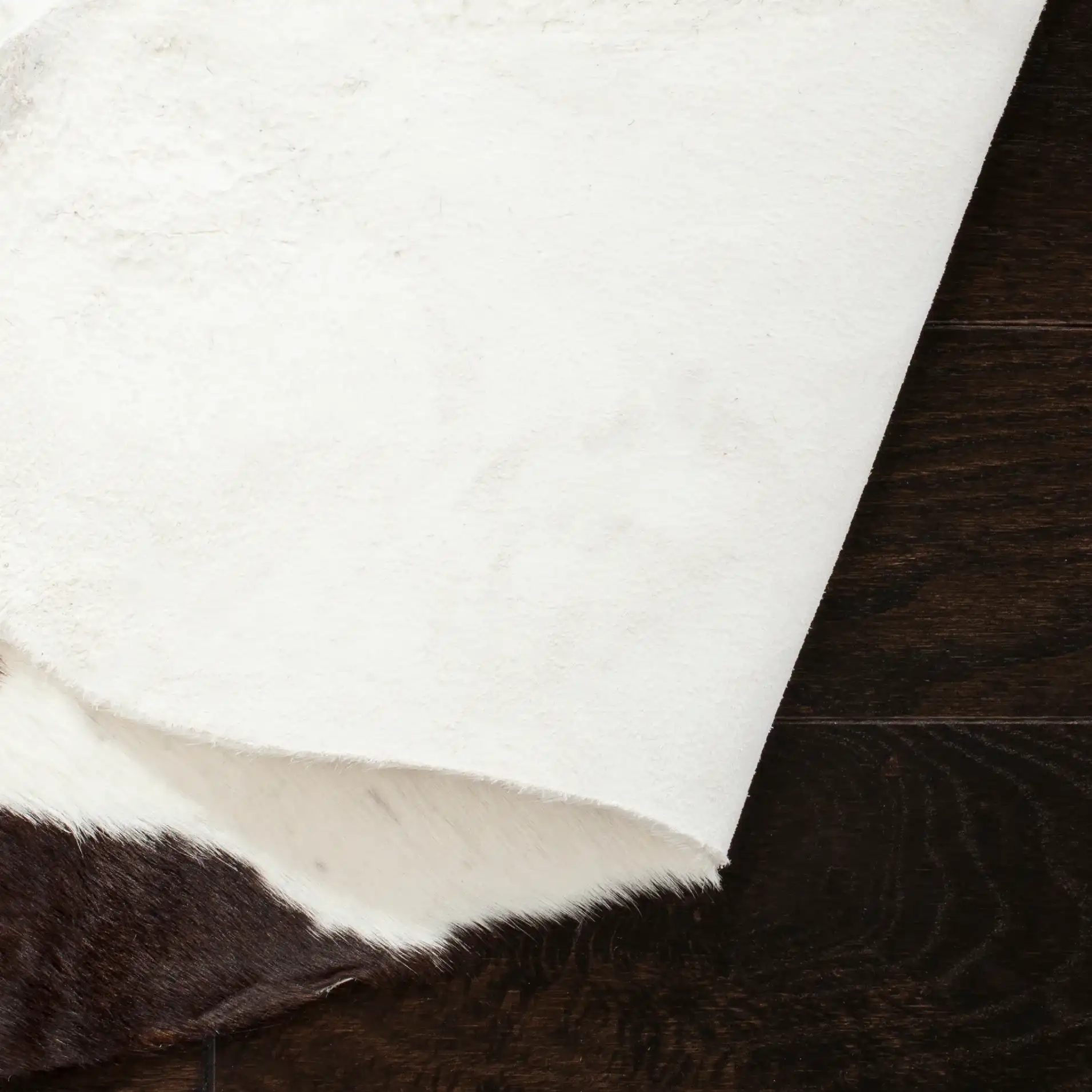 Cowhide Solid Shaped Rug in Black / White in a styled room