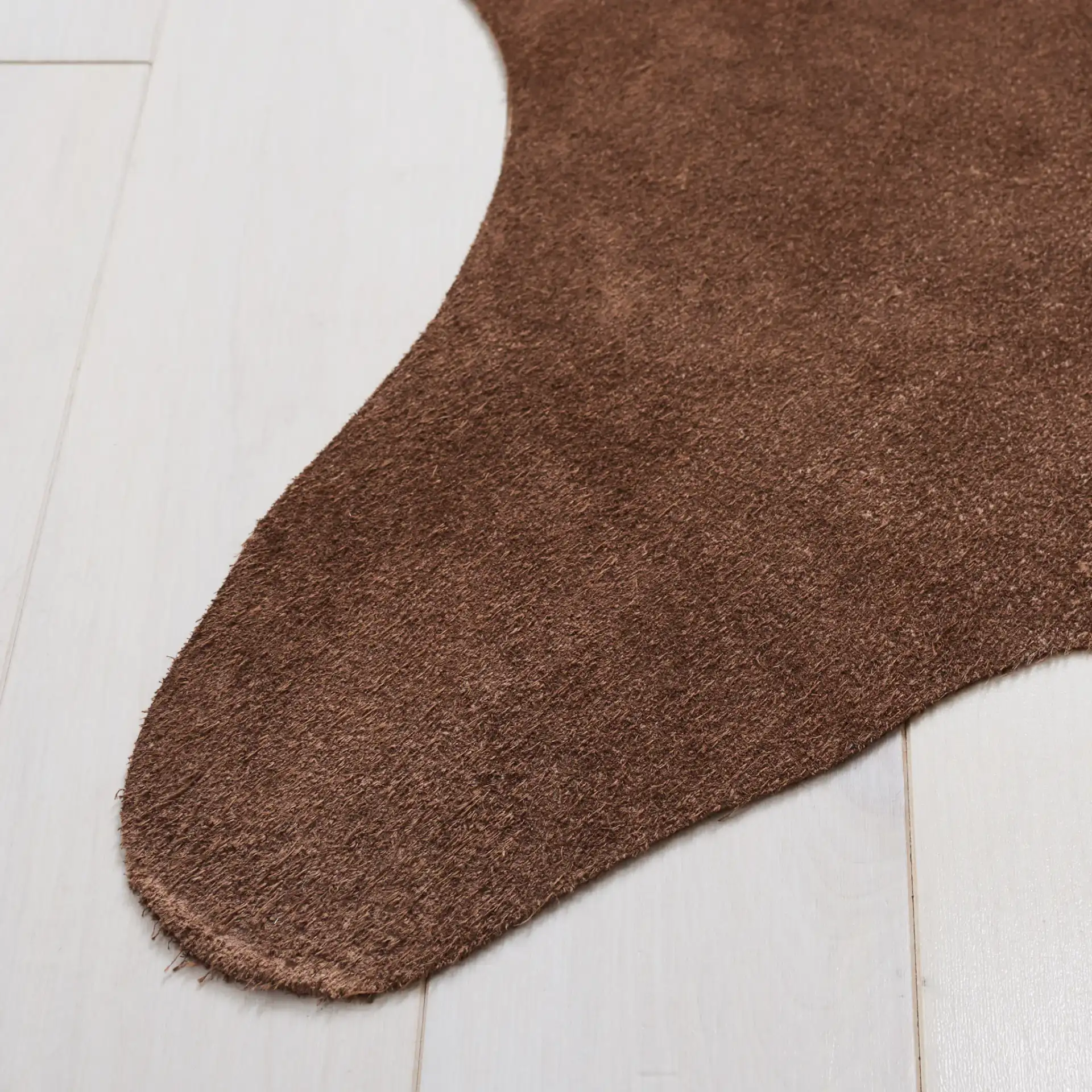 Suede Cowhide Shaped Rug in Light Brown in a styled room