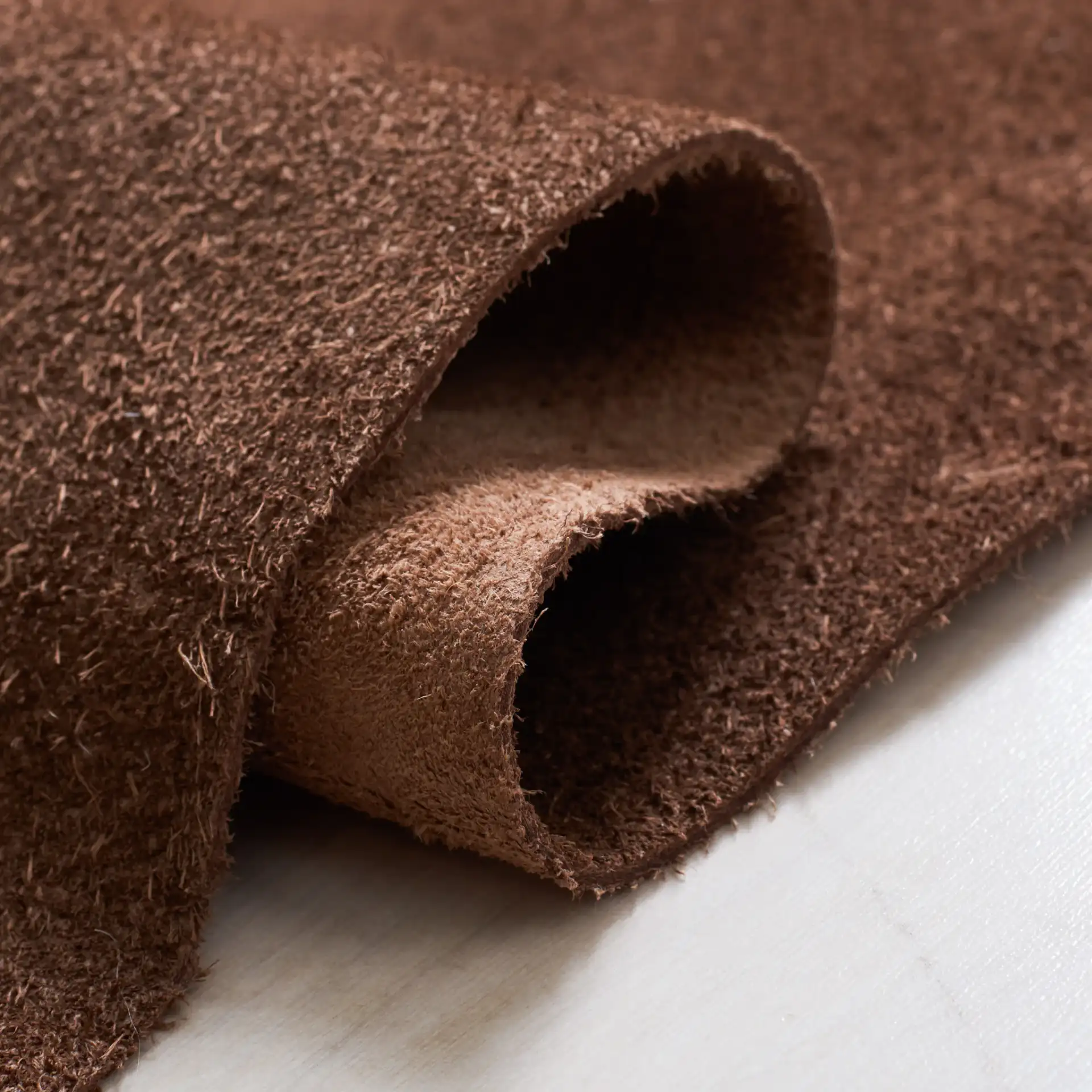 Suede Cowhide Shaped Rug in Light Brown in a styled room