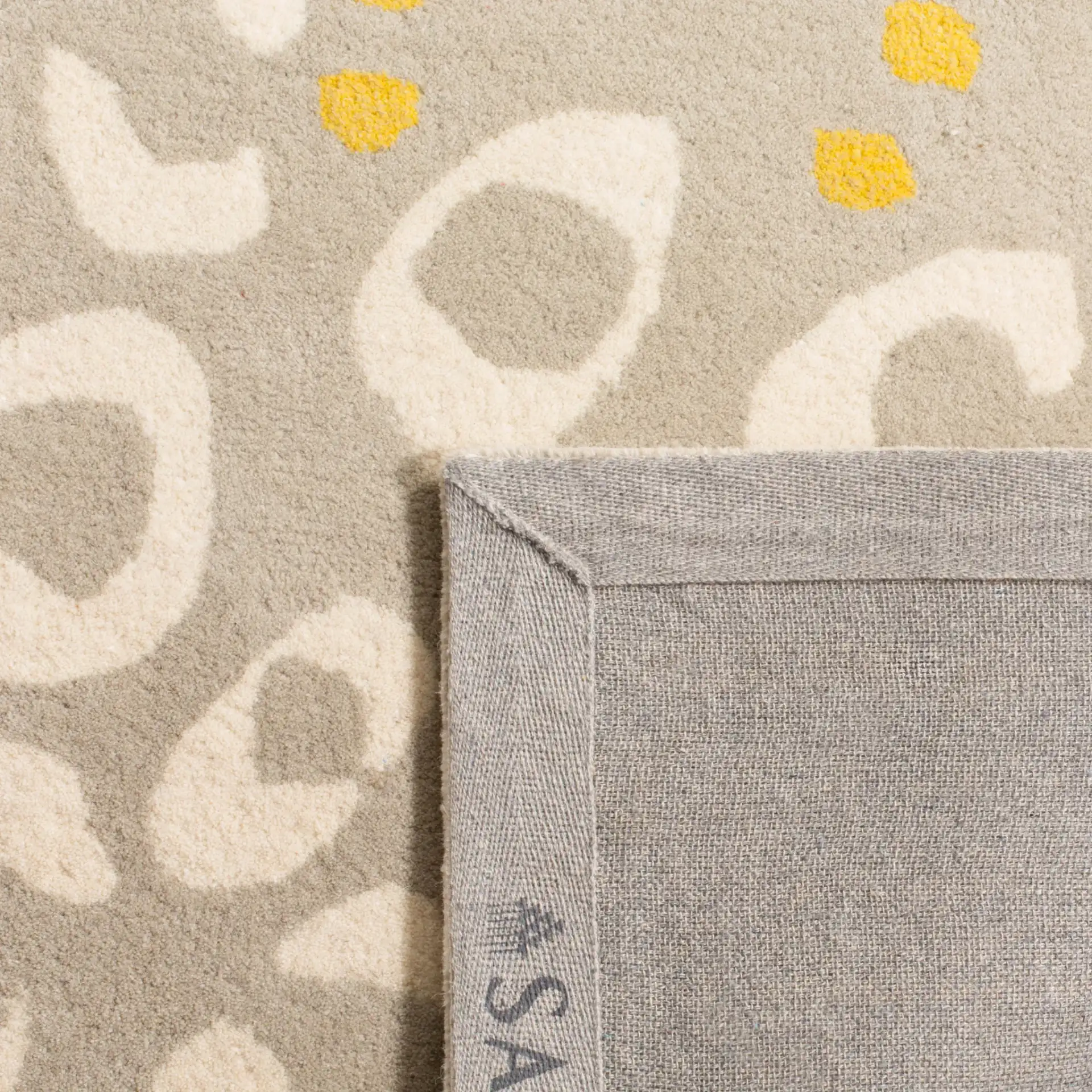 Capri Dotted Bloom Hand-Tufted Wool Rug in Gray / Ivory in a styled room