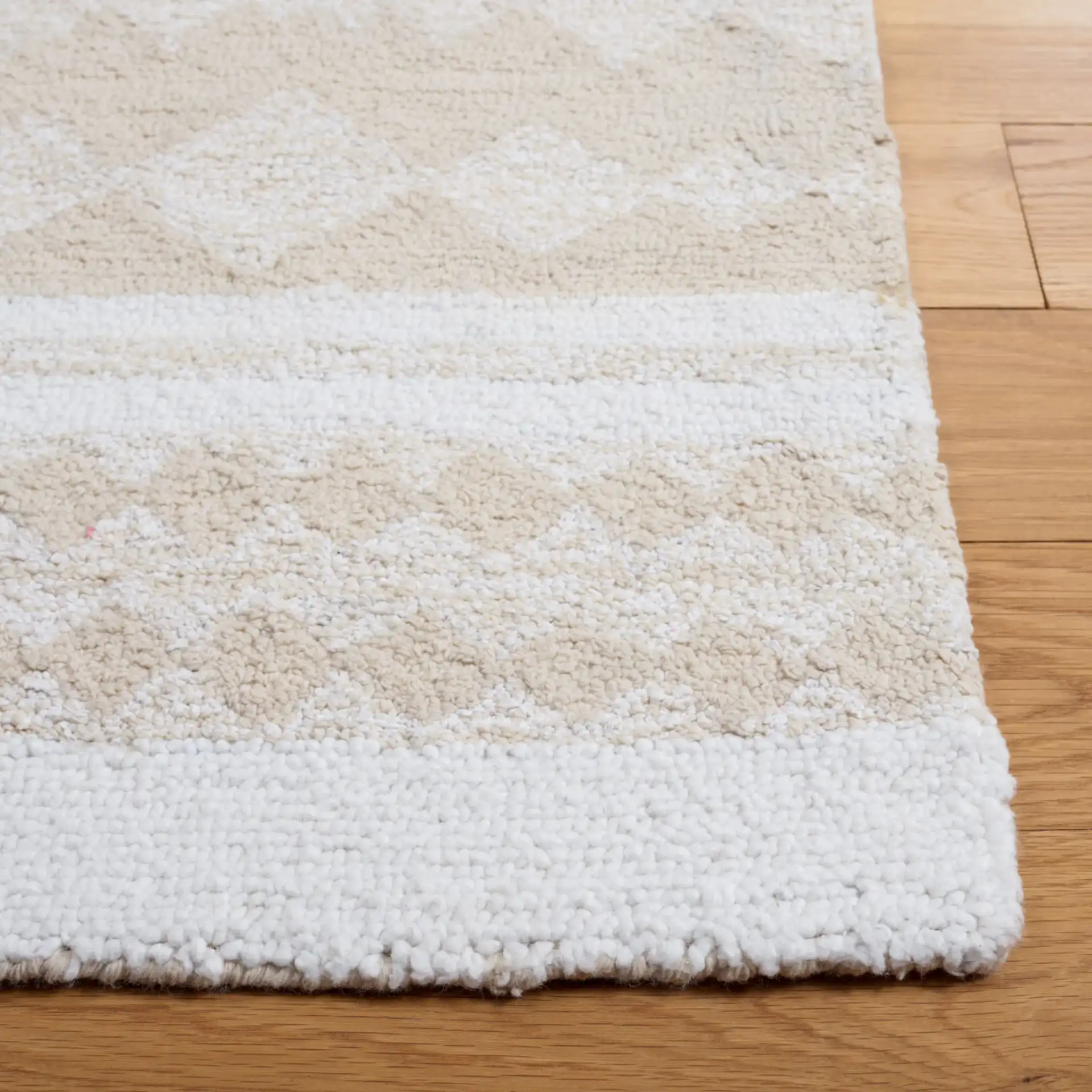 Capri Solid Bordered Hand-Tufted Rug in Ivory / Beige in a styled room