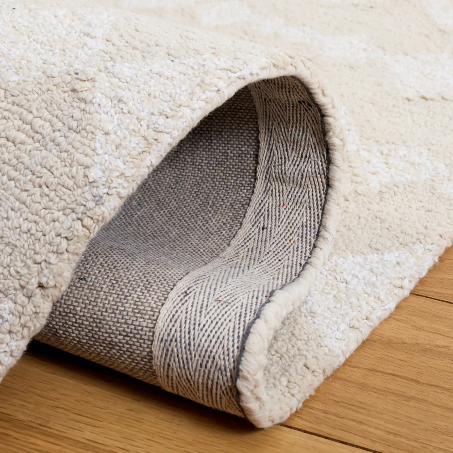 Capri Solid Bordered Hand-Tufted Rug in Ivory / Beige in a styled room