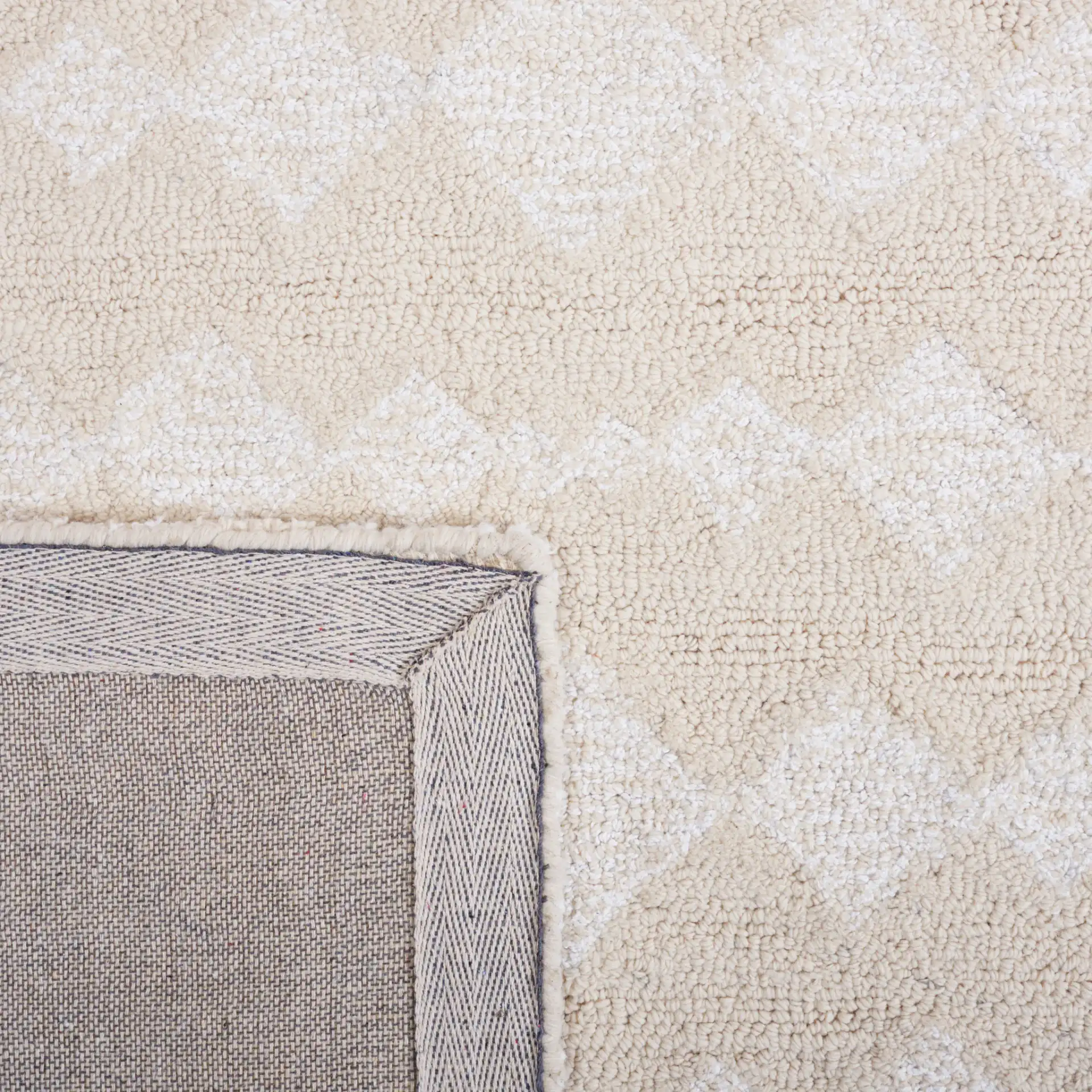 Capri Solid Bordered Hand-Tufted Rug in Ivory / Beige in a styled room
