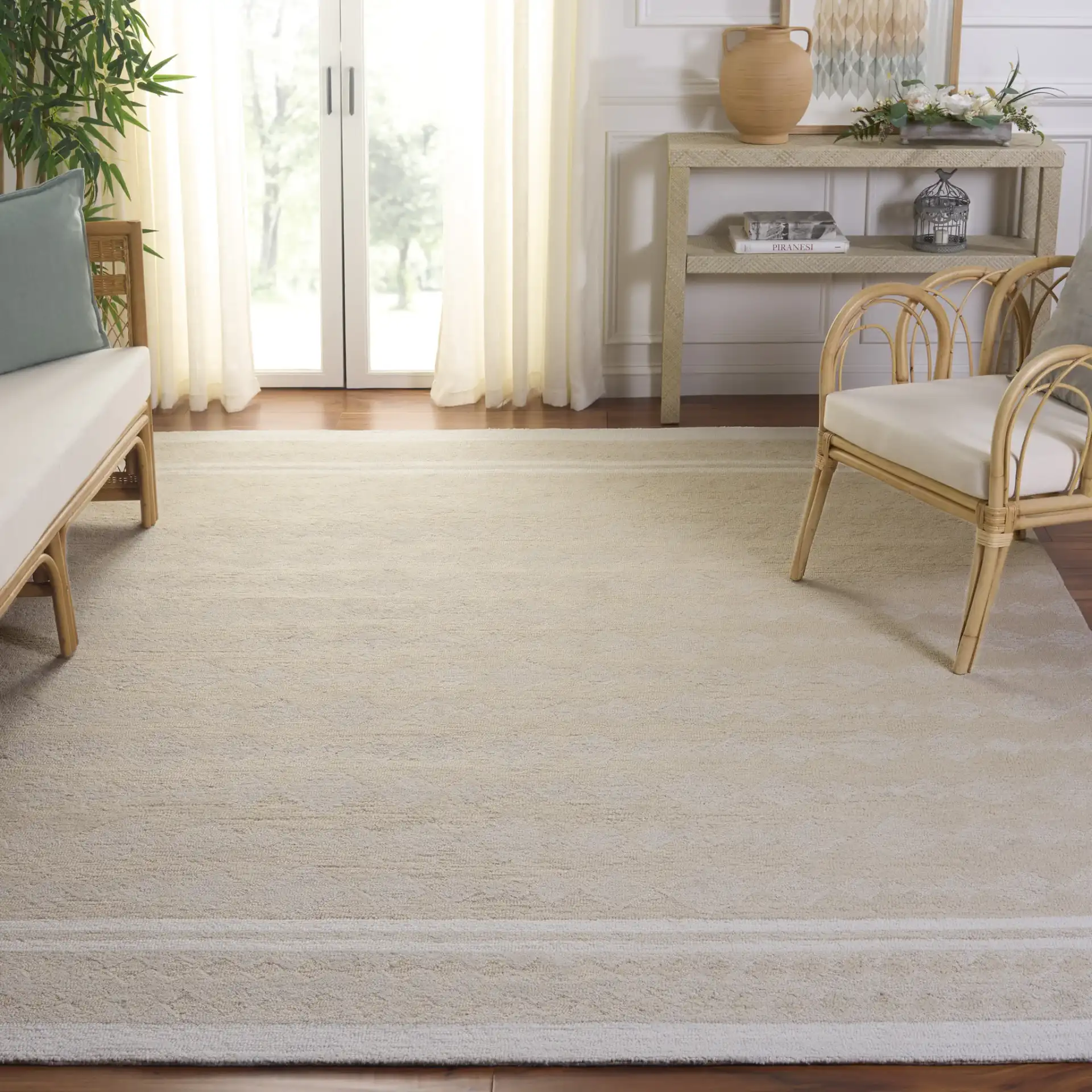 Capri Solid Bordered Hand-Tufted Rug in Ivory / Beige in a styled room
