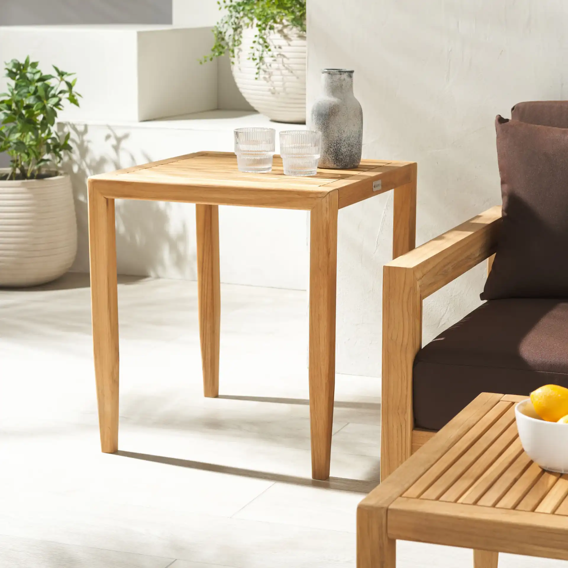 Samoa Teak Patio Accent Table in Natural in a styled room