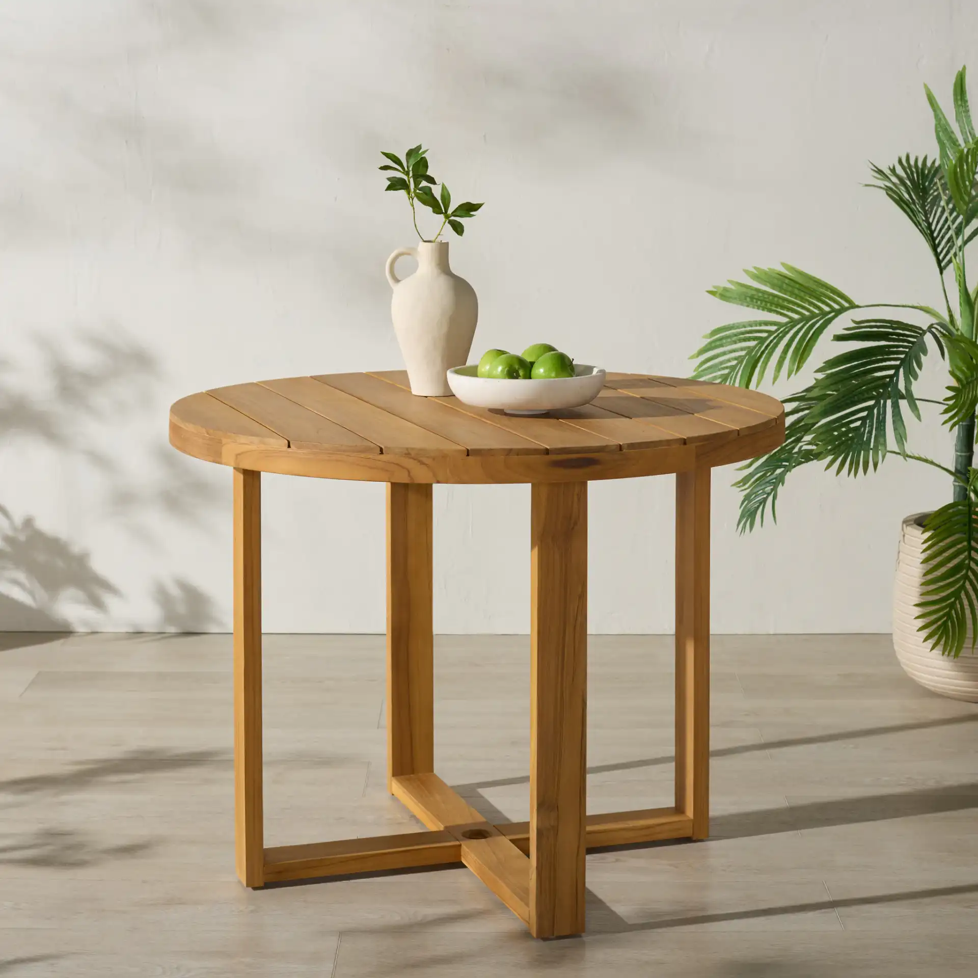 Mayaguana Round Teak Dining Table in Natural in a styled room