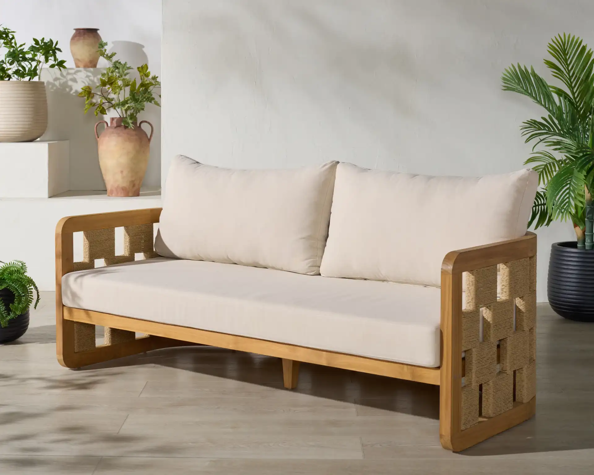 Skipper Teak Patio Sofa in Natural / Beige in a styled room