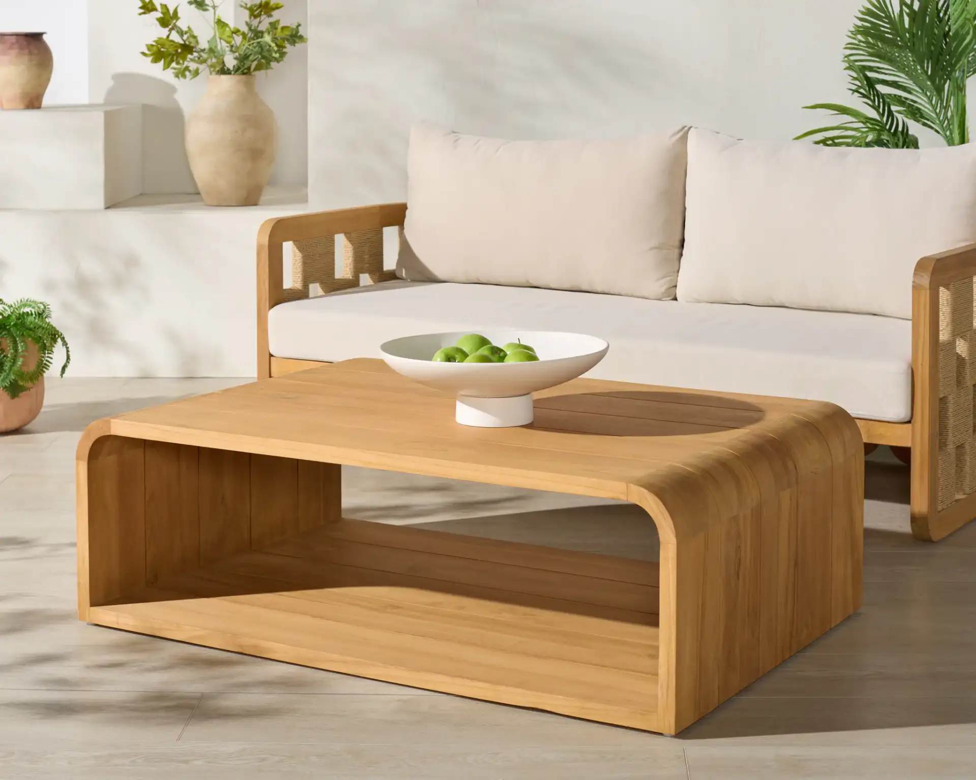 Cove Teak Outdoor Coffee Table in Natural in a styled room