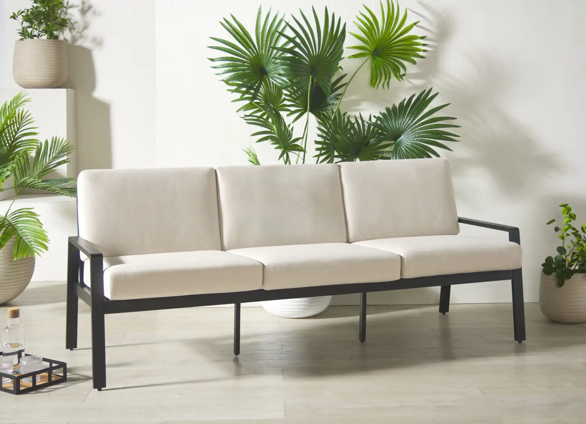 Guam Aluminum Outdoor Sofa in Black / Beige in a styled room