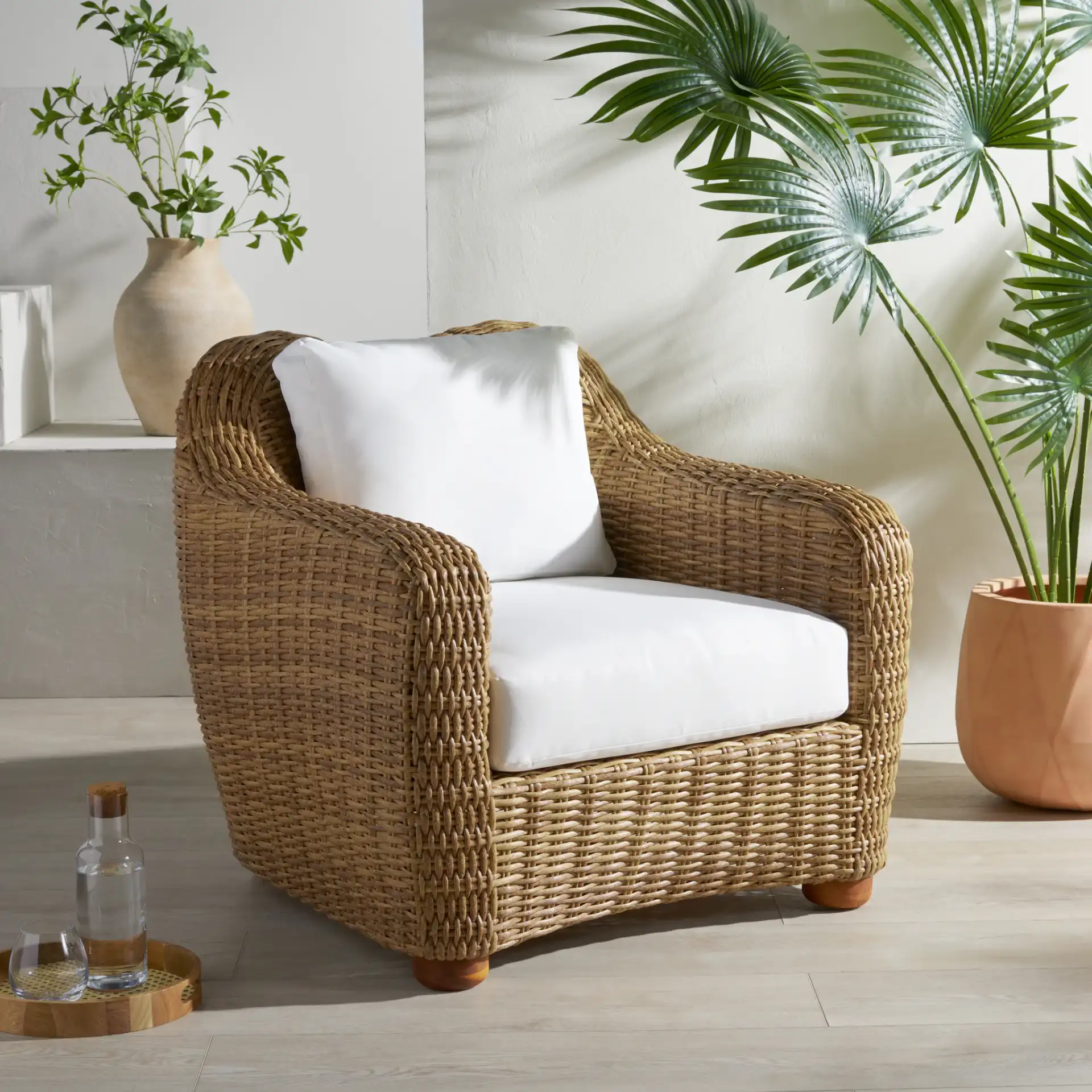 Melbourne Wicker Patio Chair in Natural / White in a styled room