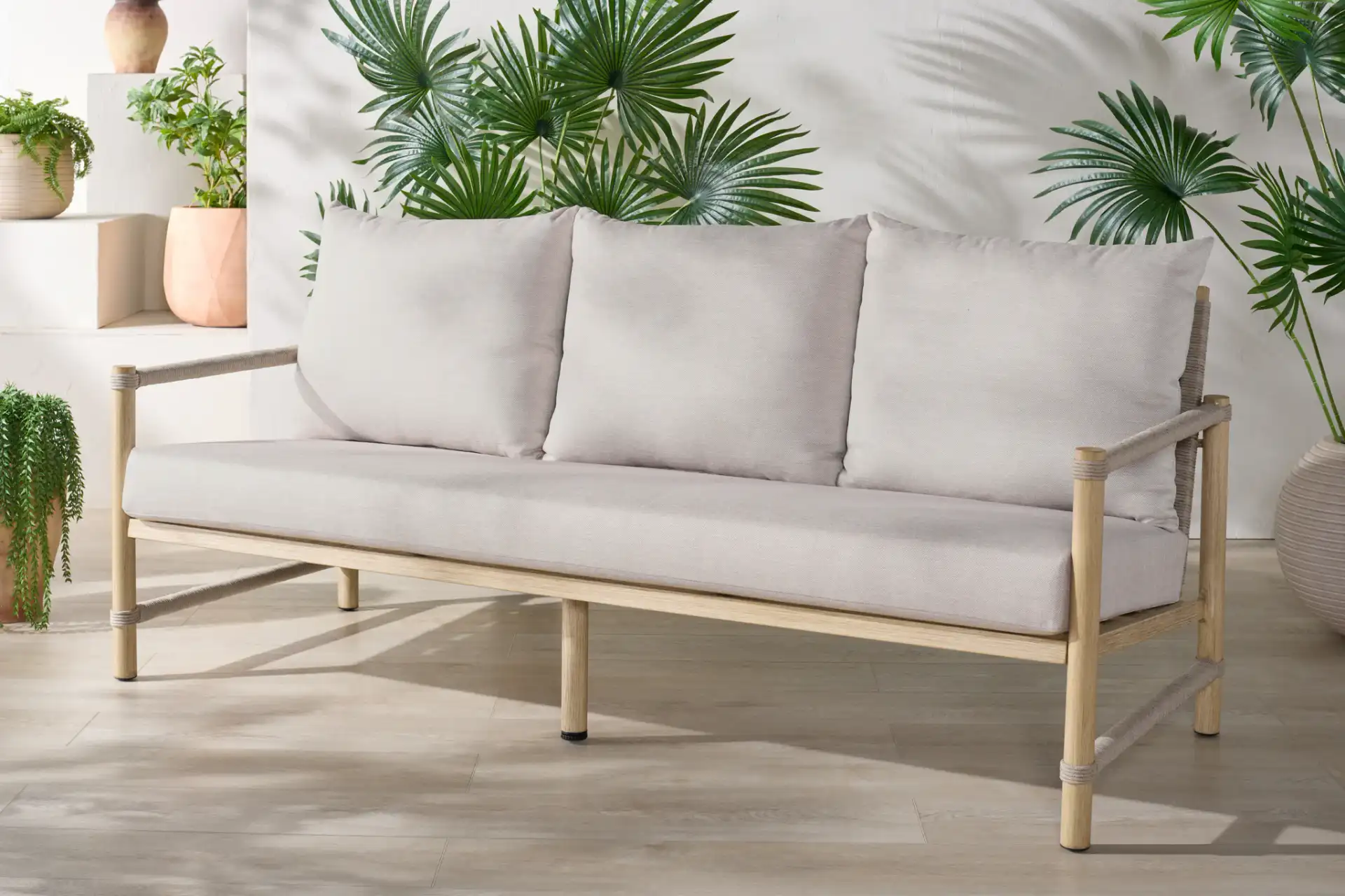 Dorianna Aluminum Patio Sofa in Sand / Beige in a styled room