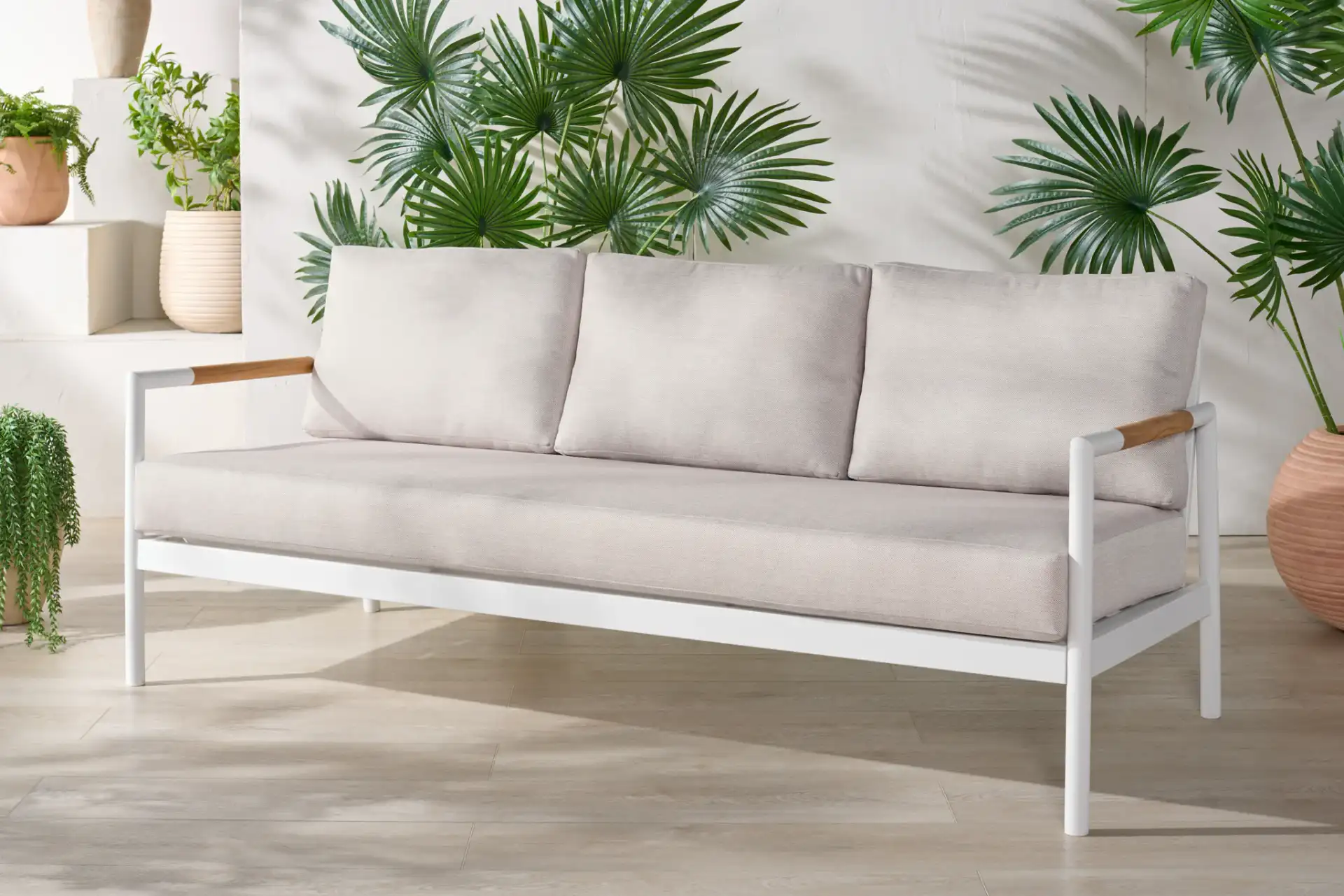 Chryssa Aluminum Patio Sofa in White / Beige in a styled room