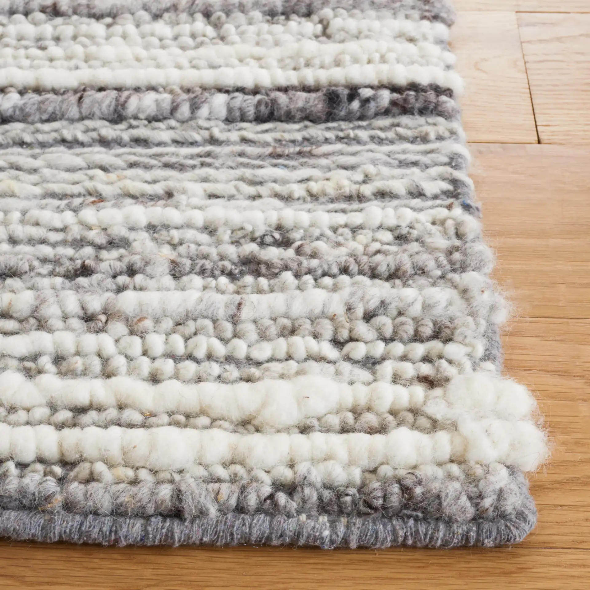 Casablanca Striped Hand-Woven Wool Rug in Gray / Ivory in a styled room