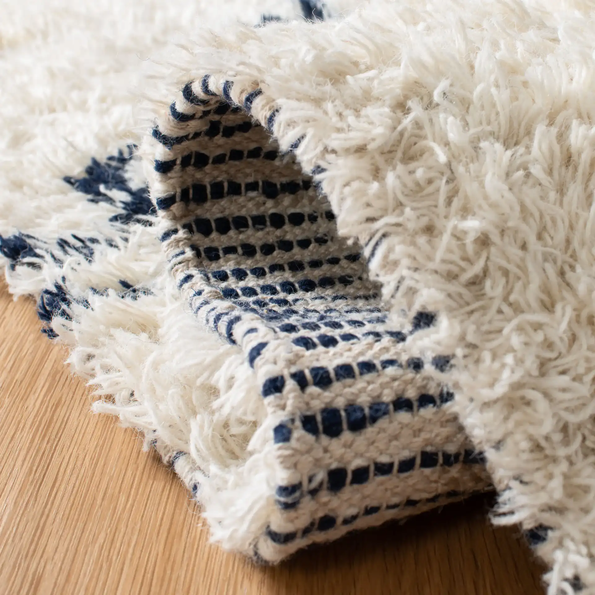Casablanca Diamond Hand-Woven Shag Wool Rug in Ivory / Navy in a styled room