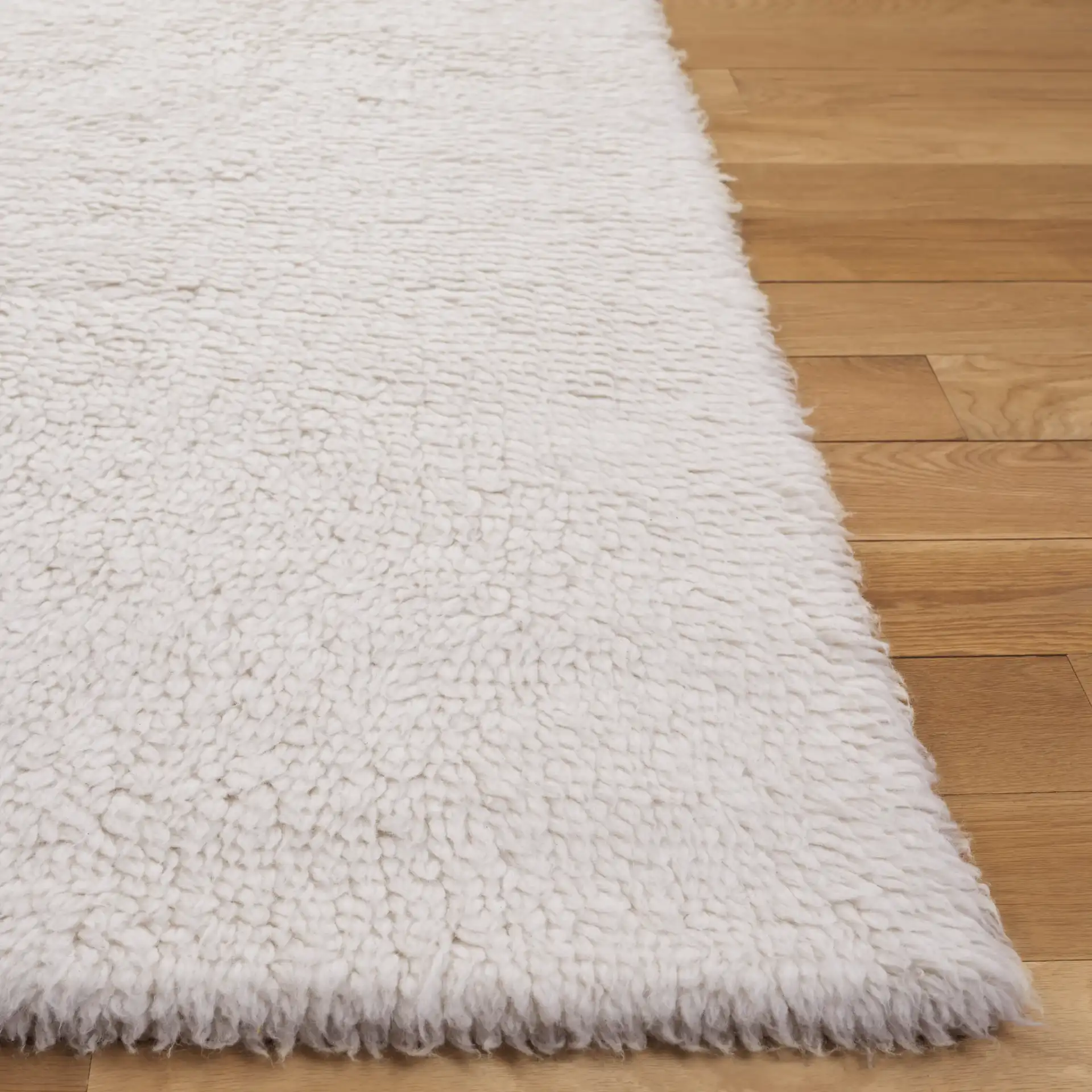 Casablanca Solid Hand-Loomed Wool Shag Rug in Ivory in a styled room