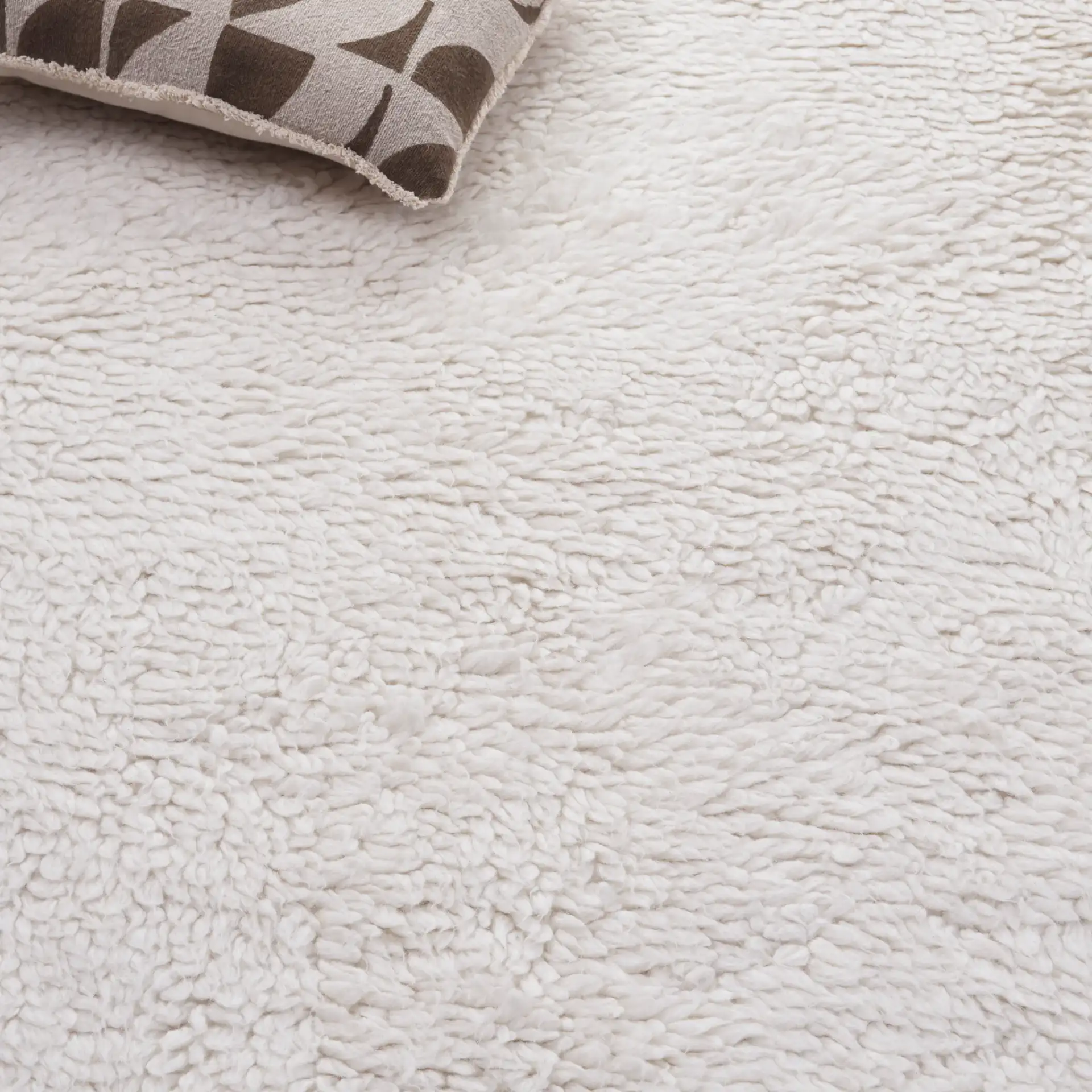 Casablanca Solid Hand-Loomed Wool Shag Rug in Ivory in a styled room