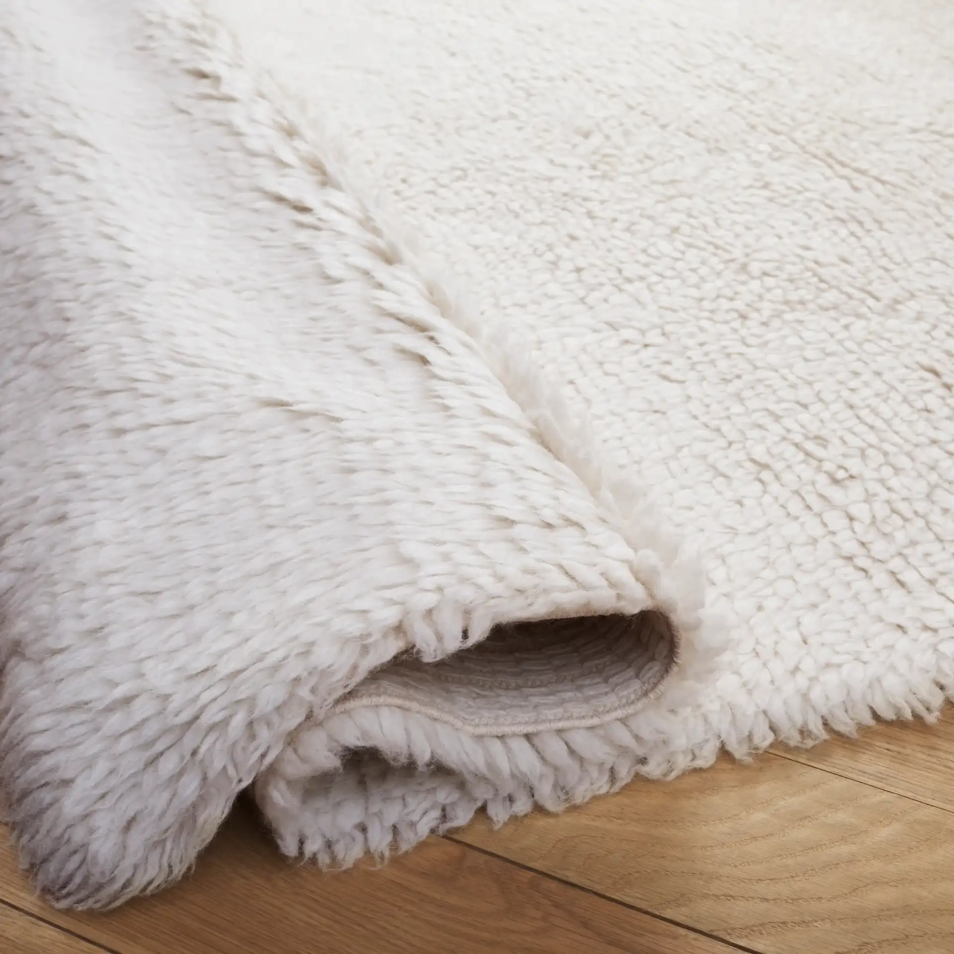 Casablanca Solid Hand-Loomed Wool Shag Rug in Ivory in a styled room