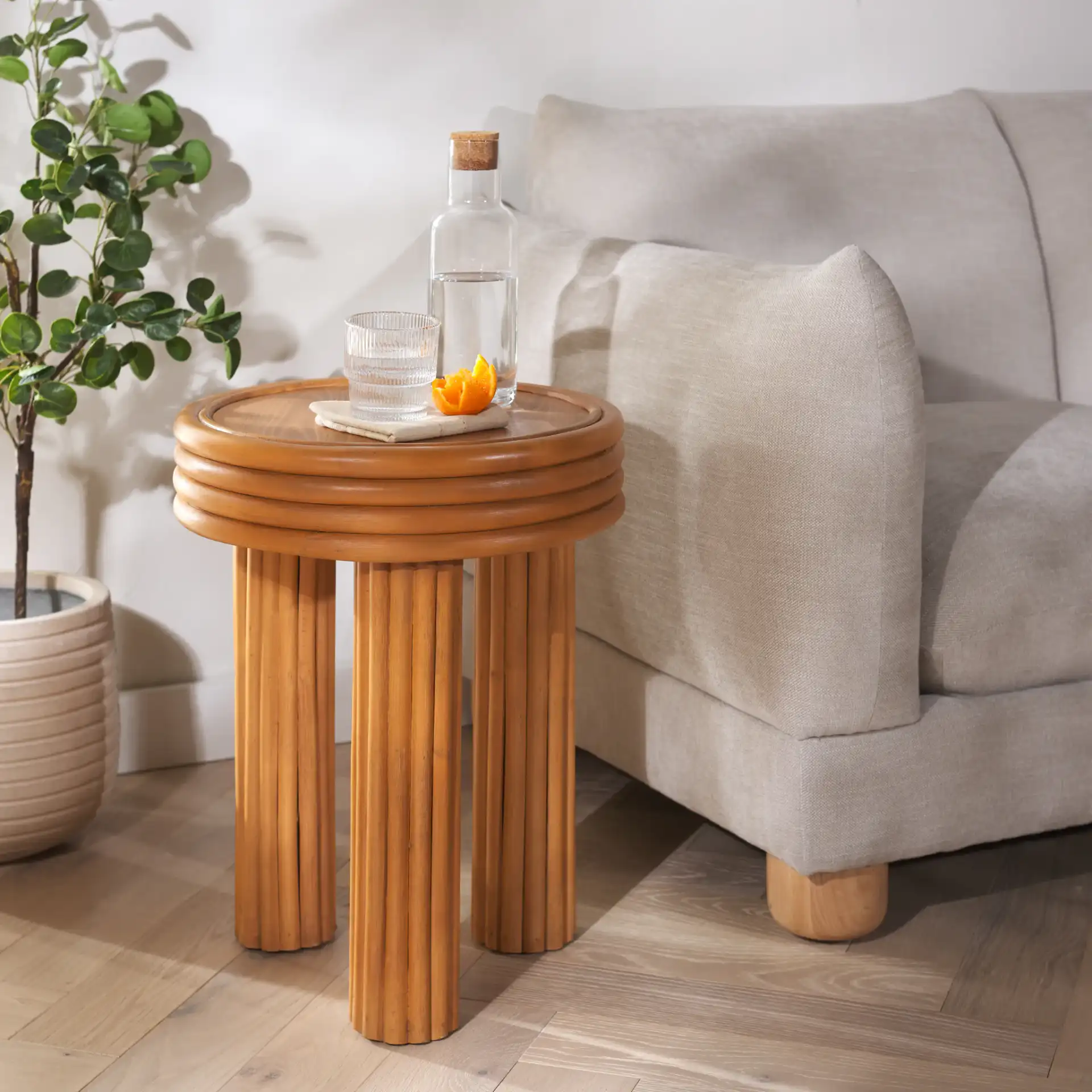Bayard Rattan Round Accent Table in Natural in a styled room