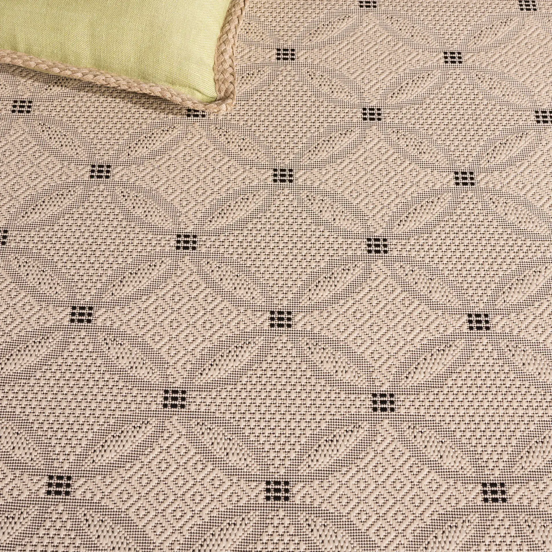 Courtyard Interlocking Ring Bordered Outdoor Rug in Sand / Black in a styled room