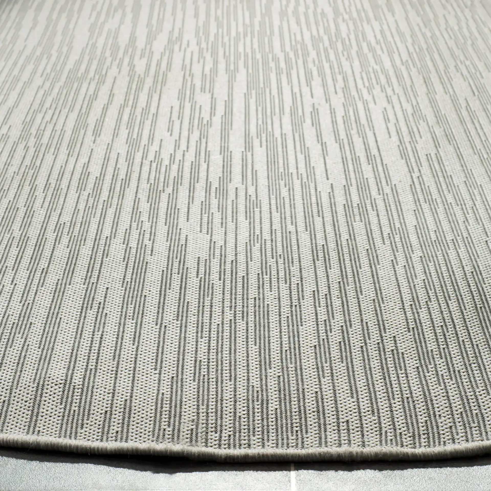Courtyard Textured Solid Outdoor Rug in Light Gray in a styled room