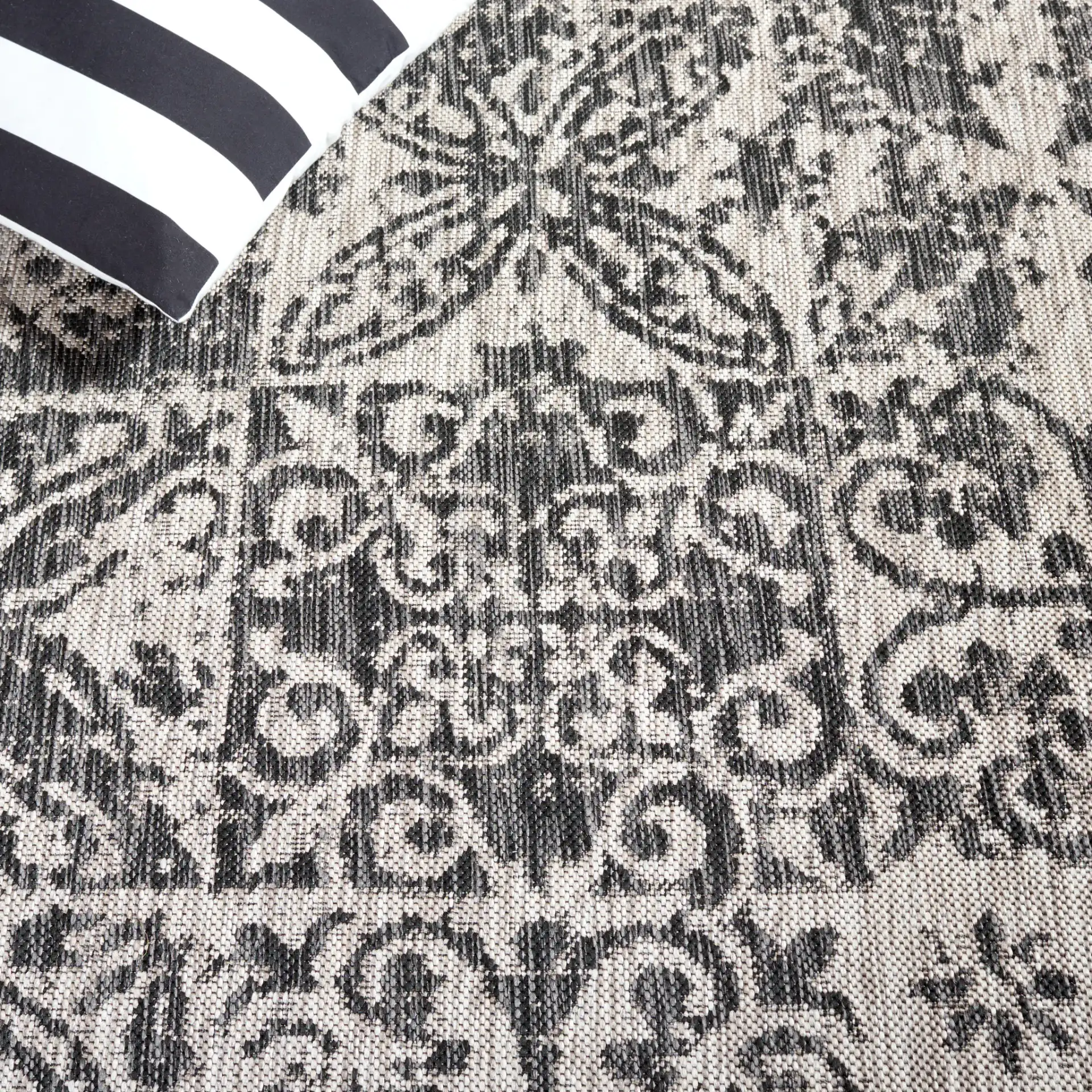 Courtyard Distressed Tile Patchwork Outdoor Rug in Black / Beige in a styled room