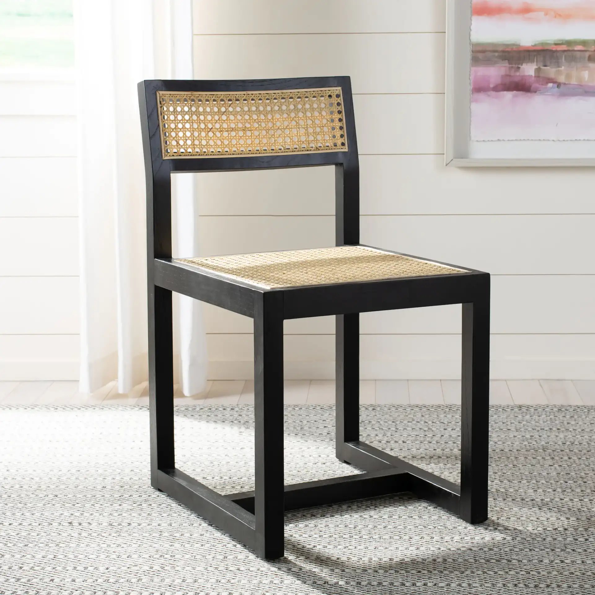 Bernice Cane Dining Chair in Black / Natural in a styled room