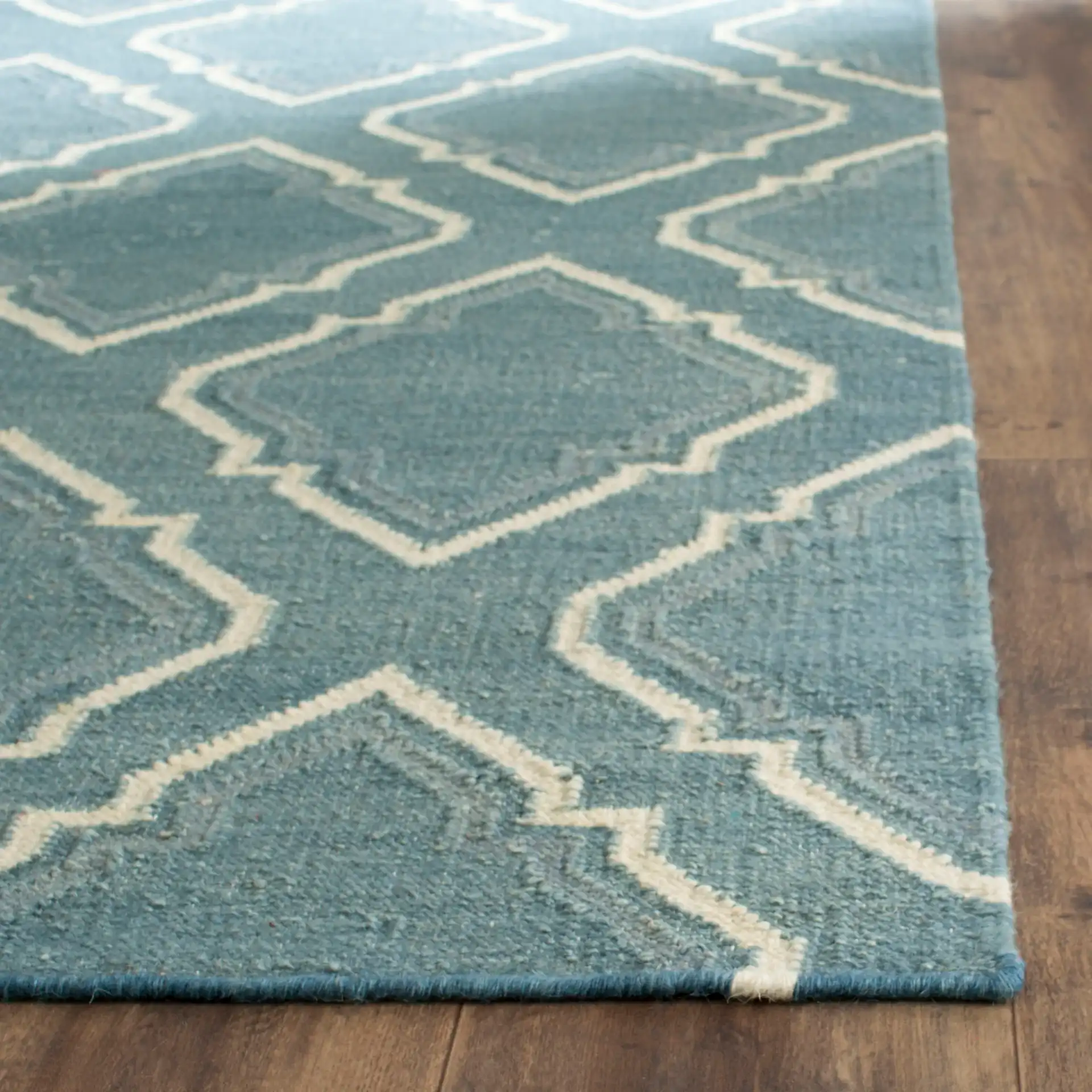 Dhurries Stepped Ogee Trellis Hand-Woven Wool Rug in Blue / Ivory in a styled room