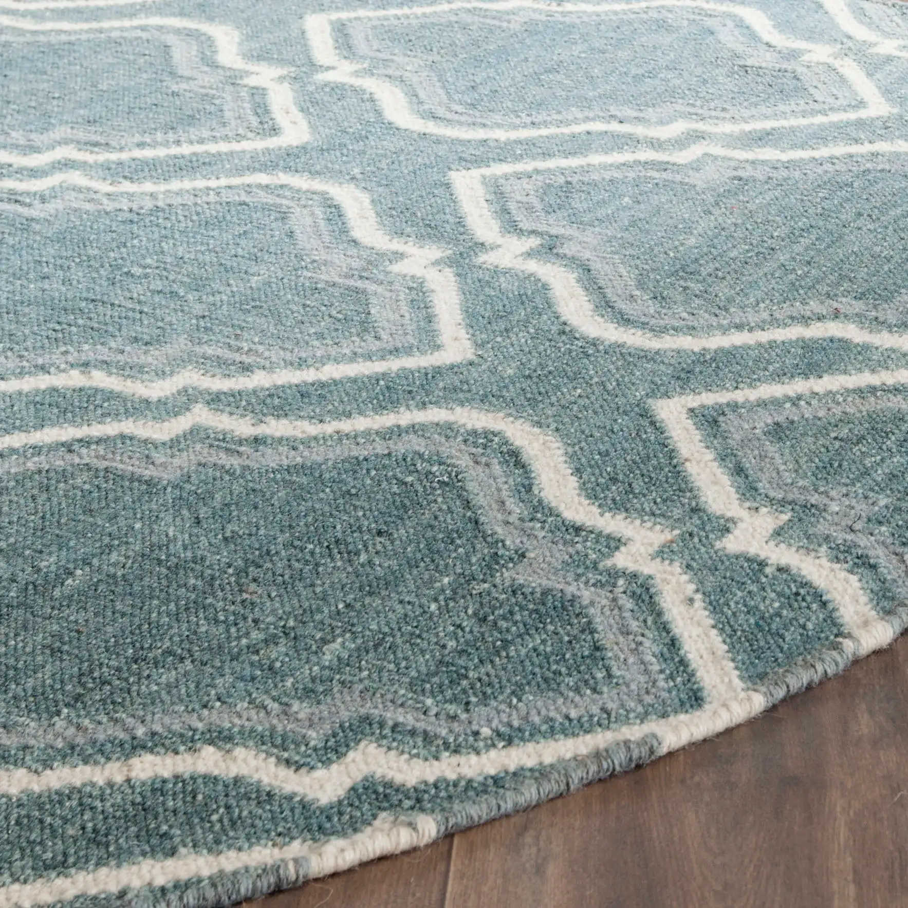 Dhurries Stepped Ogee Trellis Hand-Woven Wool Rug in Blue / Ivory in a styled room