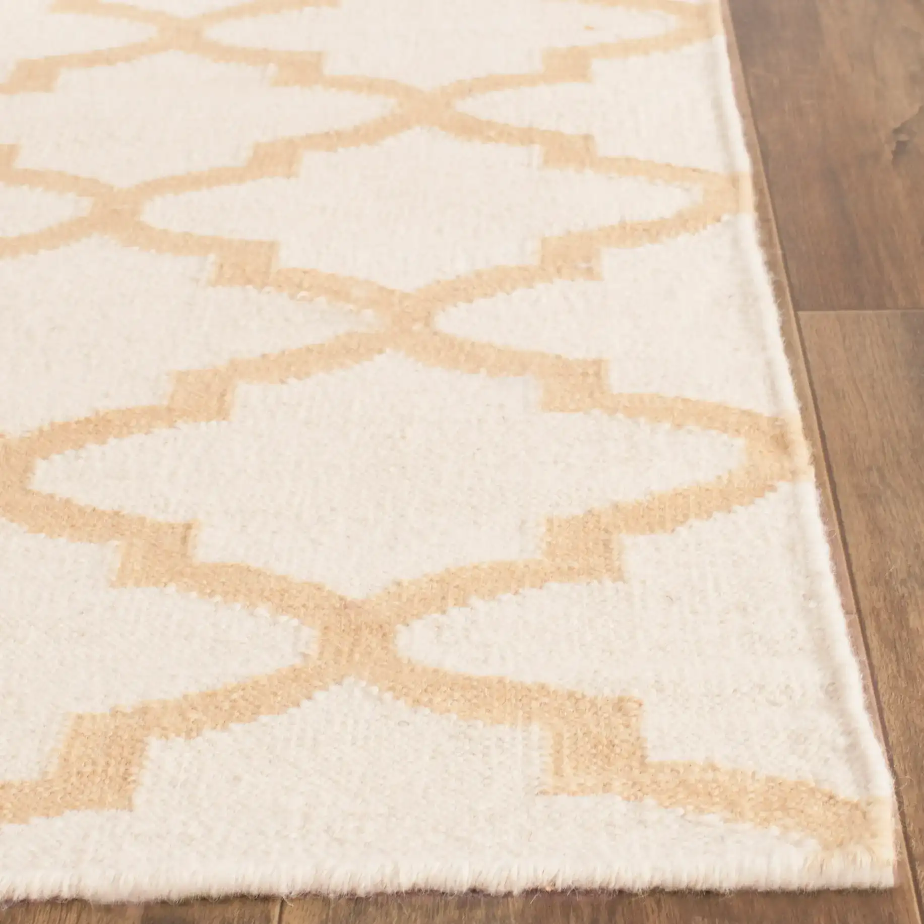 Dhurries Ogee Trellis Hand-Woven Wool Rug in Ivory / Gold in a styled room
