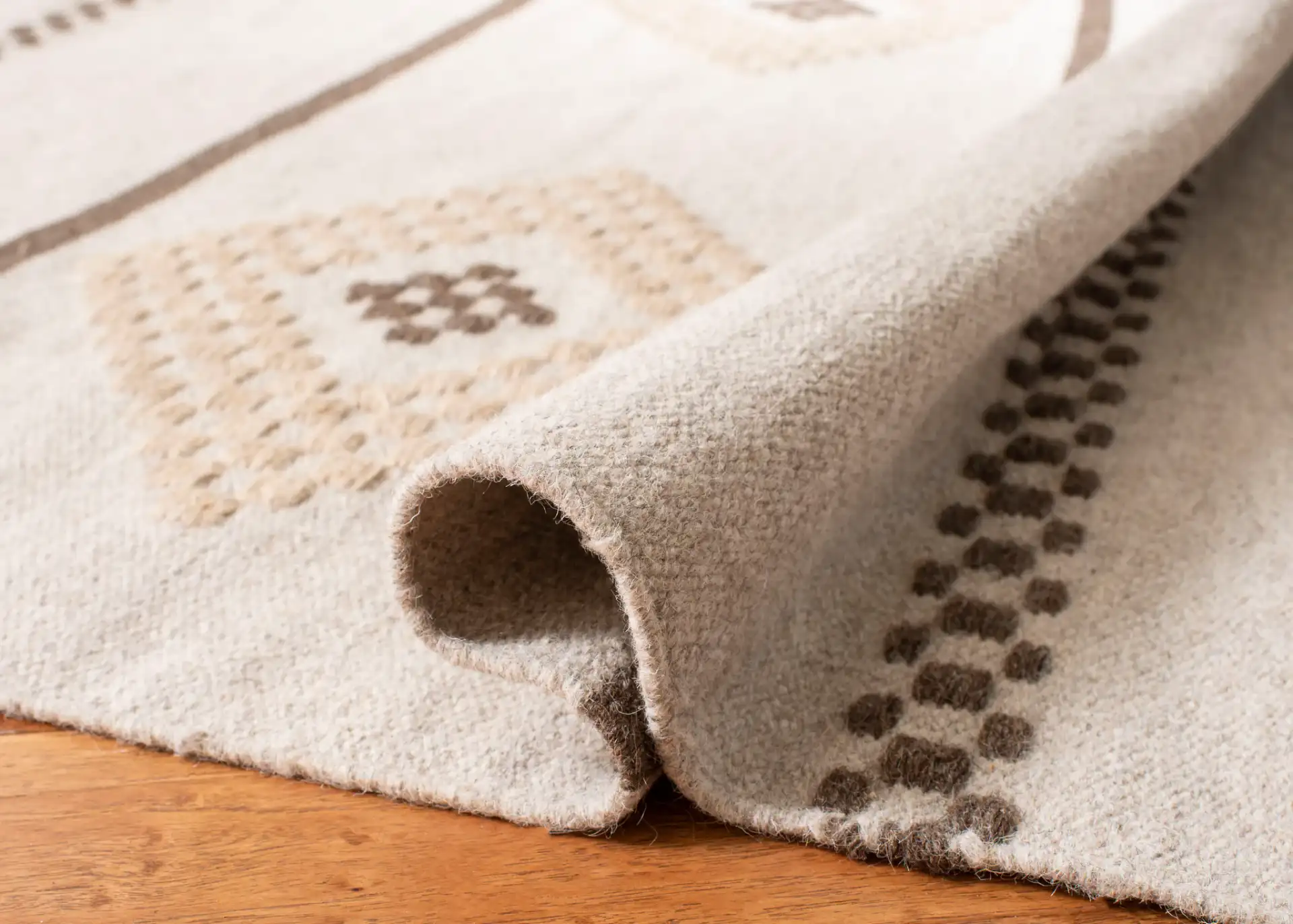 Dhurries Banded Diamond Hand-Woven Wool Rug in Natural in a styled room
