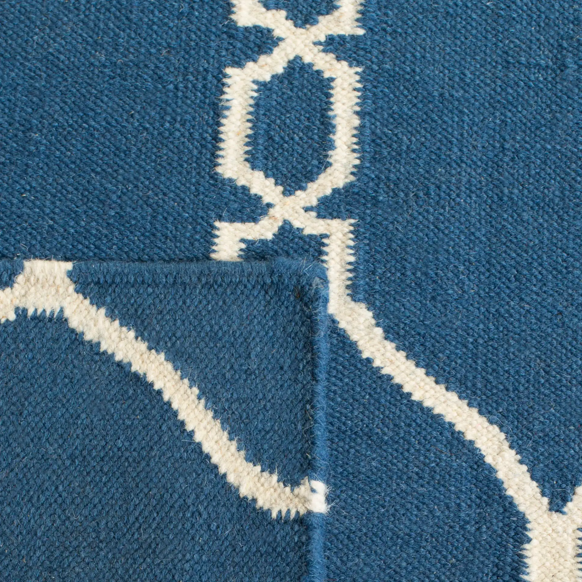 Dhurries Linked Trellis Hand-Woven Wool Rug in Dark Blue in a styled room