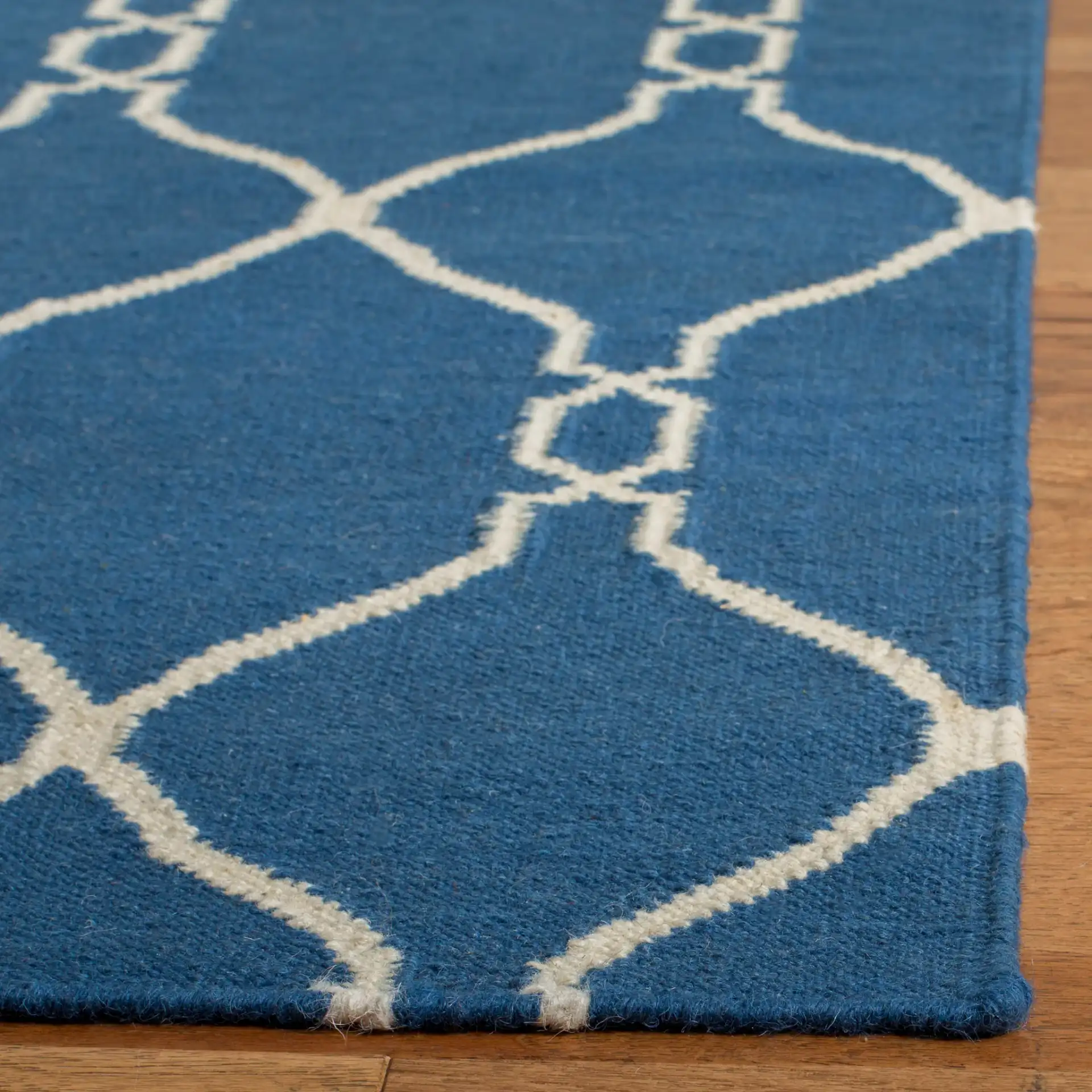 Dhurries Linked Trellis Hand-Woven Wool Rug in Dark Blue in a styled room