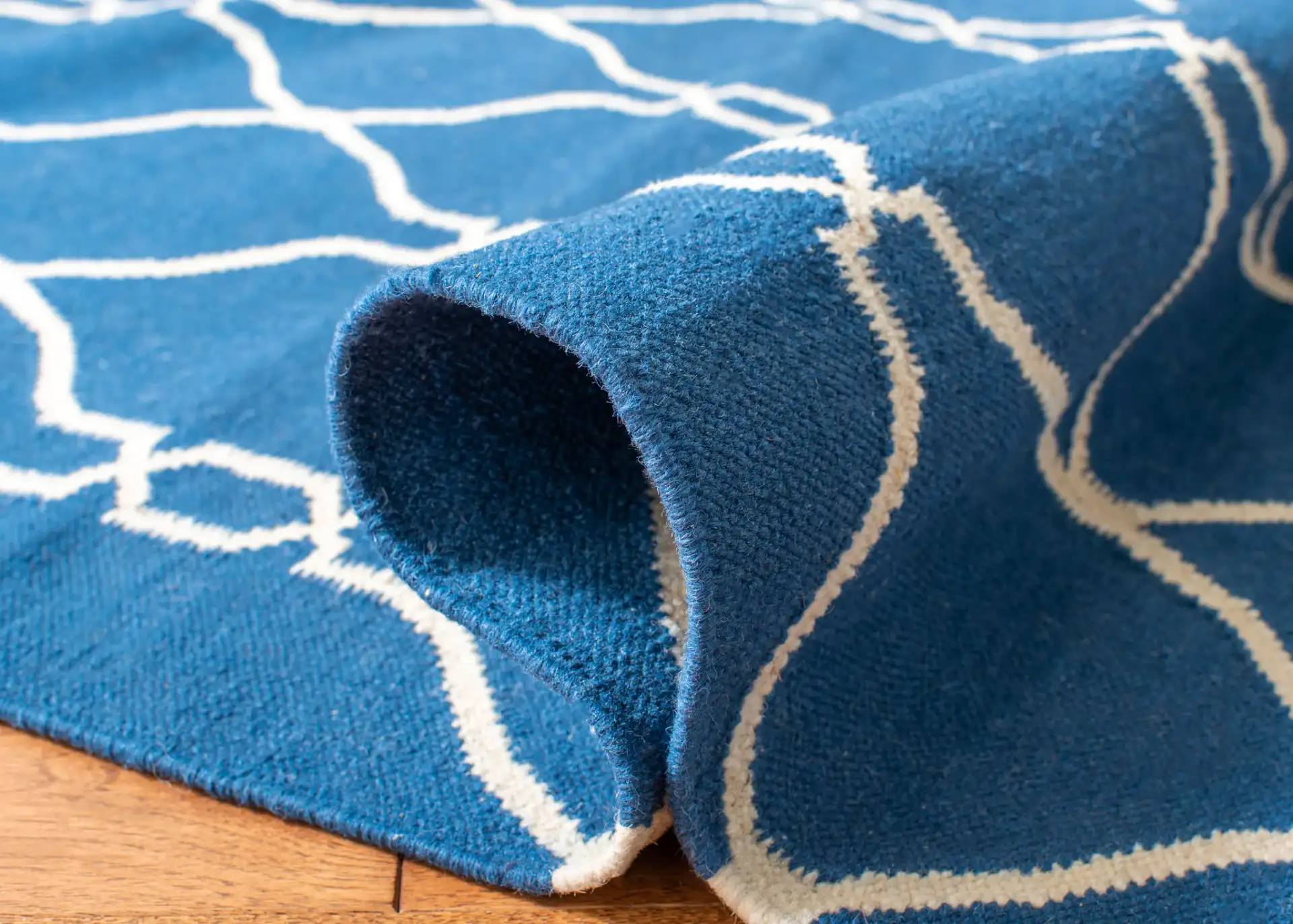 Dhurries Linked Trellis Hand-Woven Wool Rug in Dark Blue in a styled room