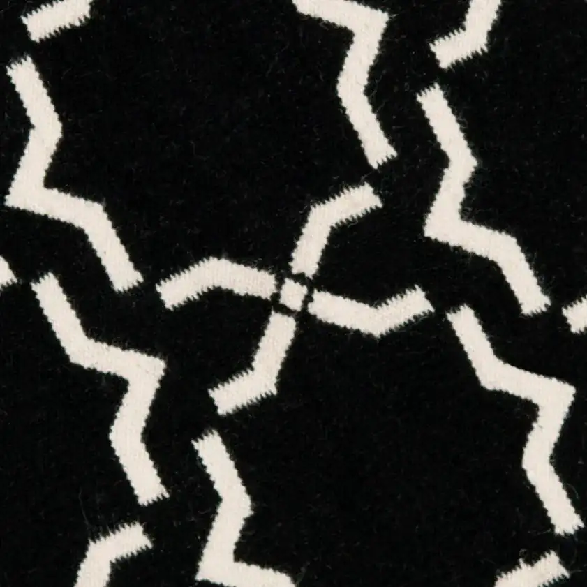 Dhurries Bordered Geometric Trellis Hand-Woven Rug in Black / Ivory in a styled room