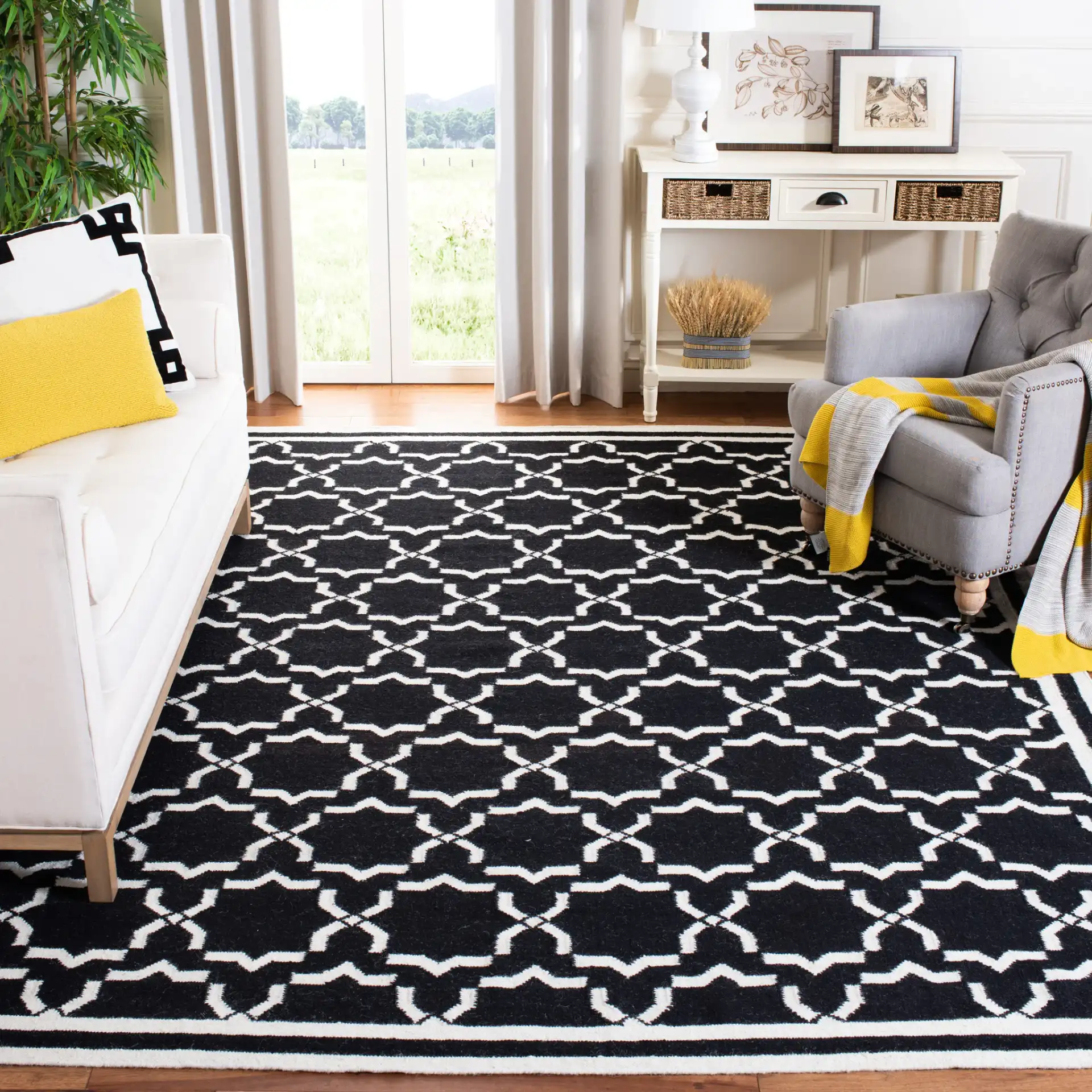 Dhurries Bordered Geometric Trellis Hand-Woven Rug in Black / Ivory in a styled room