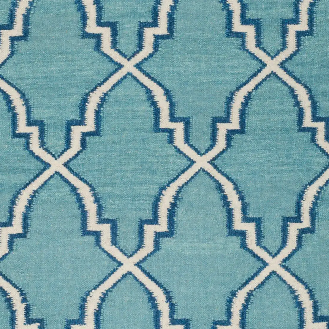 Dhurries Elongated Trellis Hand-Woven Rug in Light Blue / Ivory in a styled room